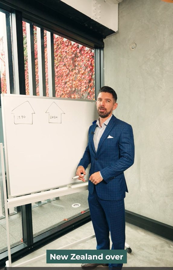 Joseph (CEO) standing in front of whiteboard, about to explain inflation and house prices in NZ