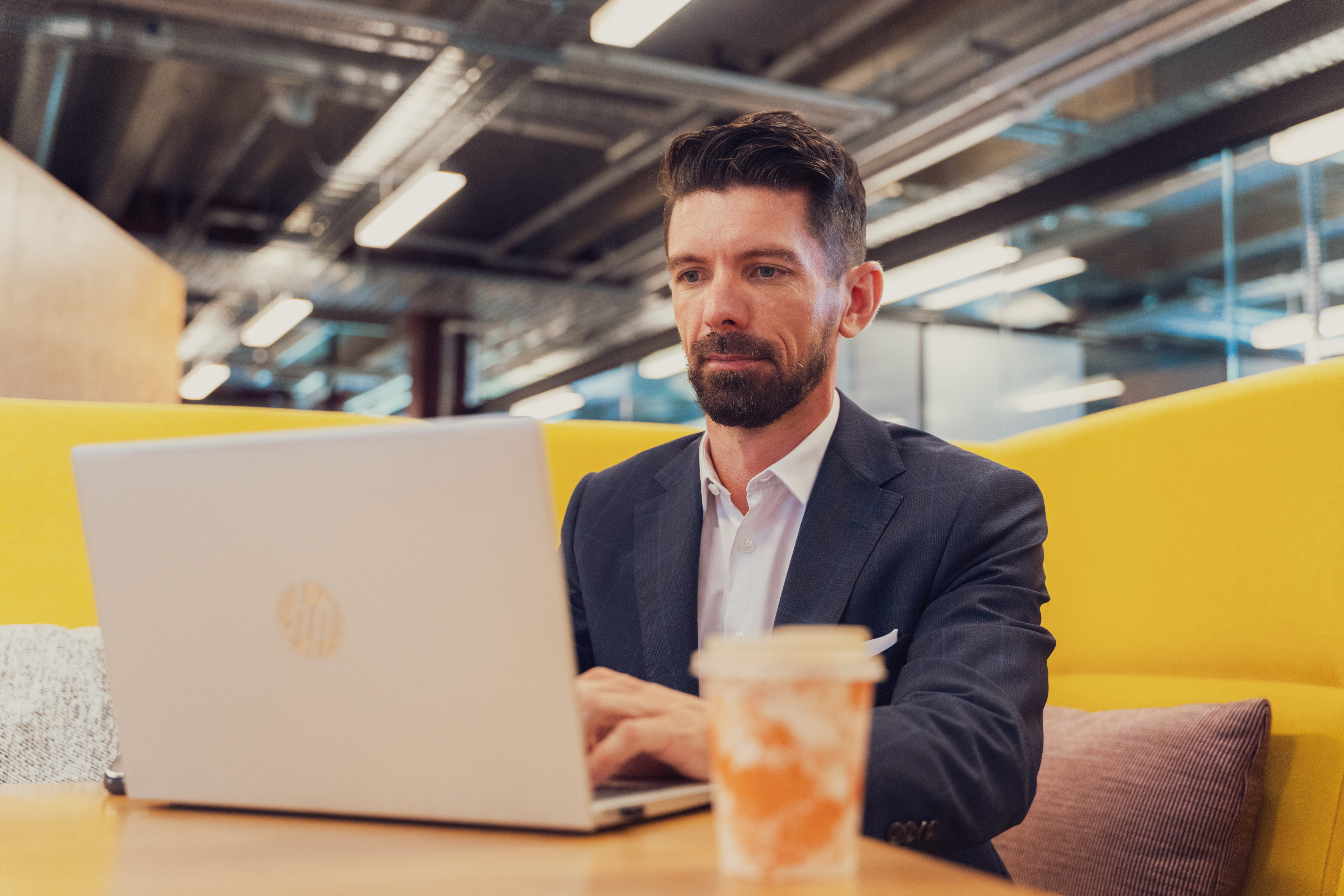 Joseph Darby, CEO of Become Wealth, seated at a laptop, analysing a client's investment portfolio