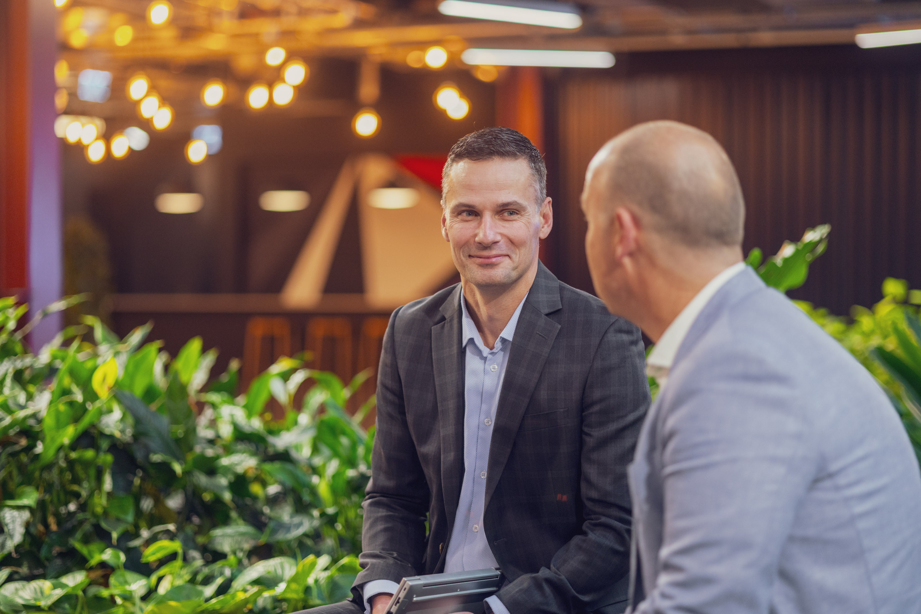 One of Become Wealth's financial advisers, Jonny McNamee, seated, talking with an elderly client