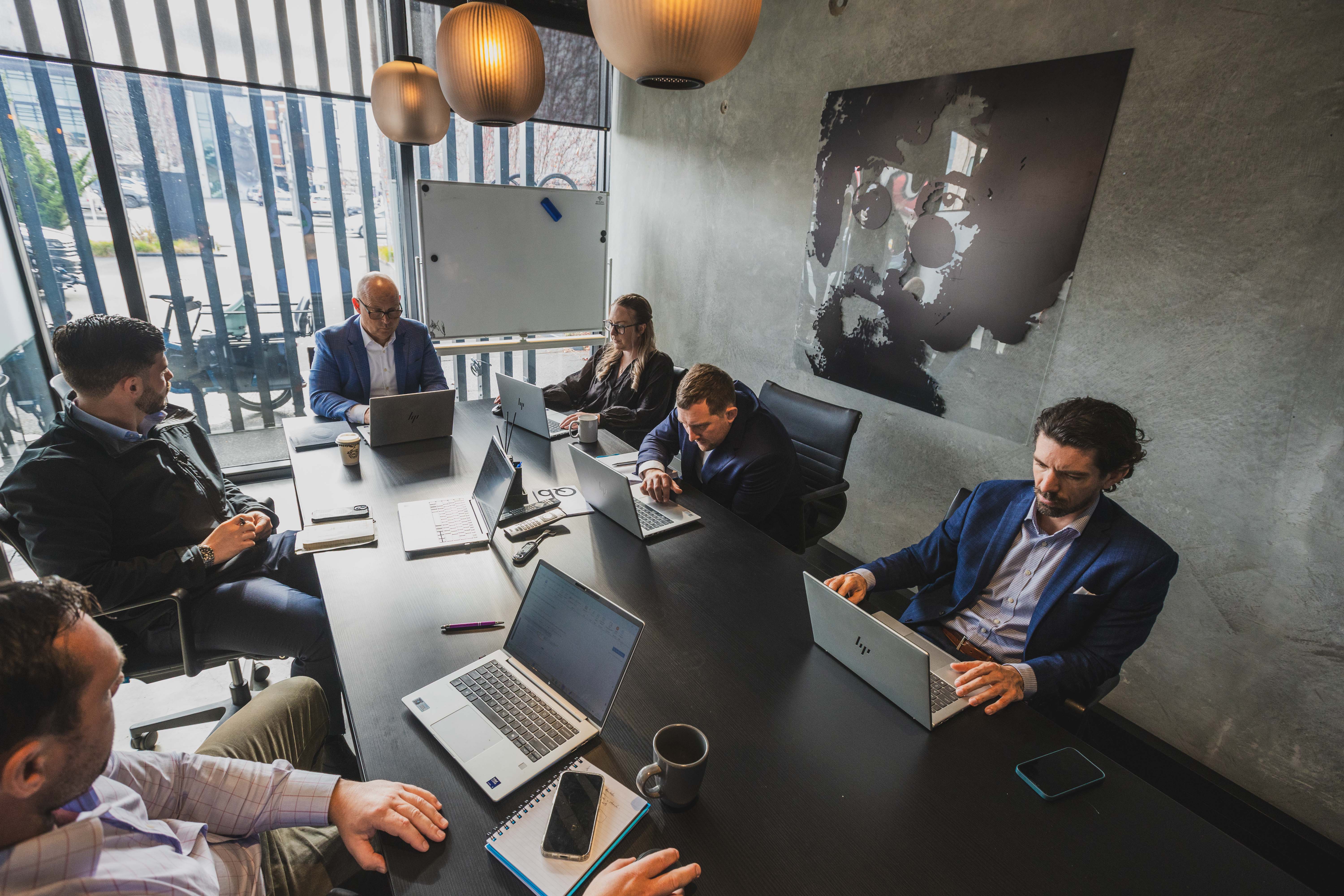 The Become Wealth financial advice team together in the firm's office, meeting, discussing property and other investments