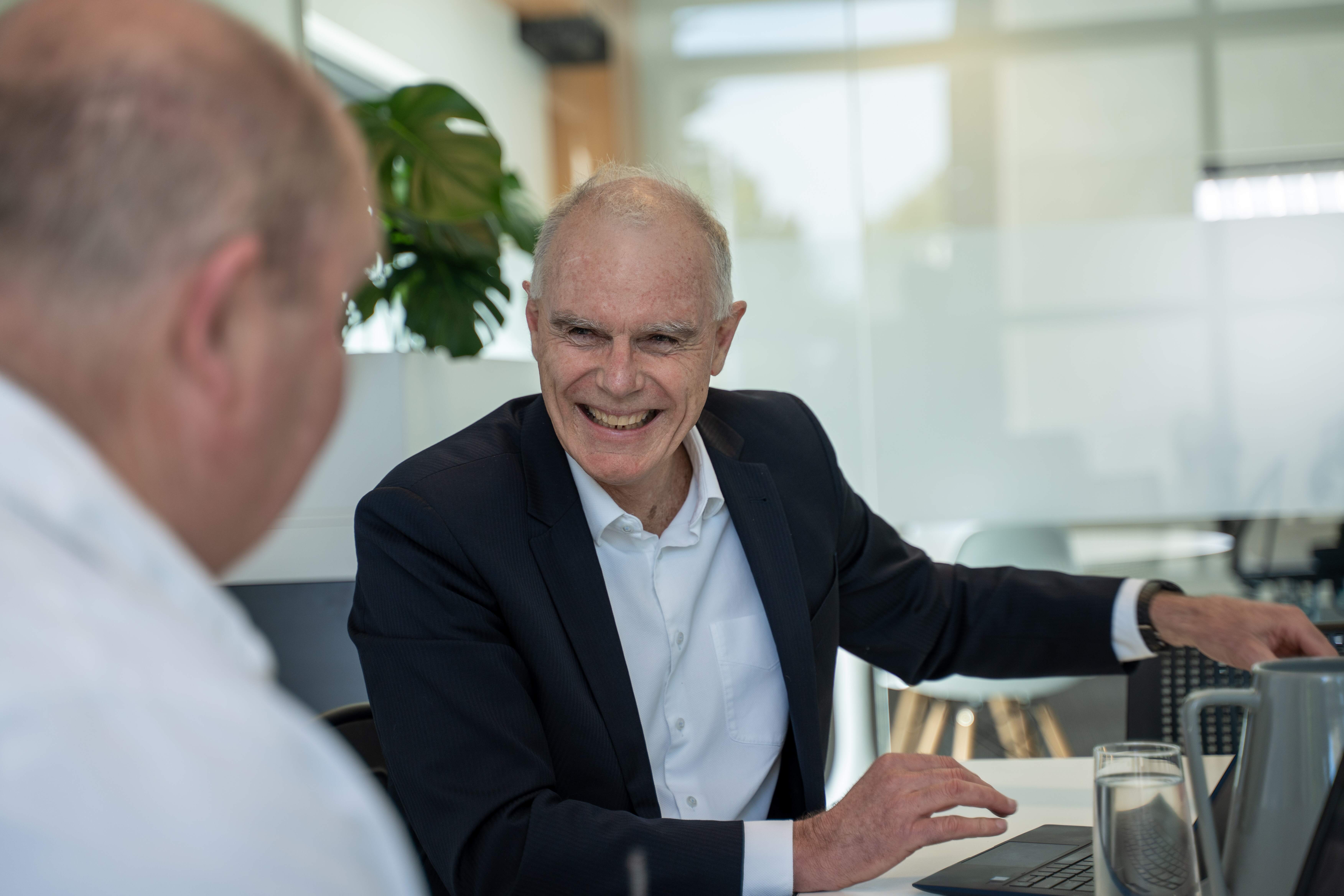Become Wealth chairman, seated facing a client in the office