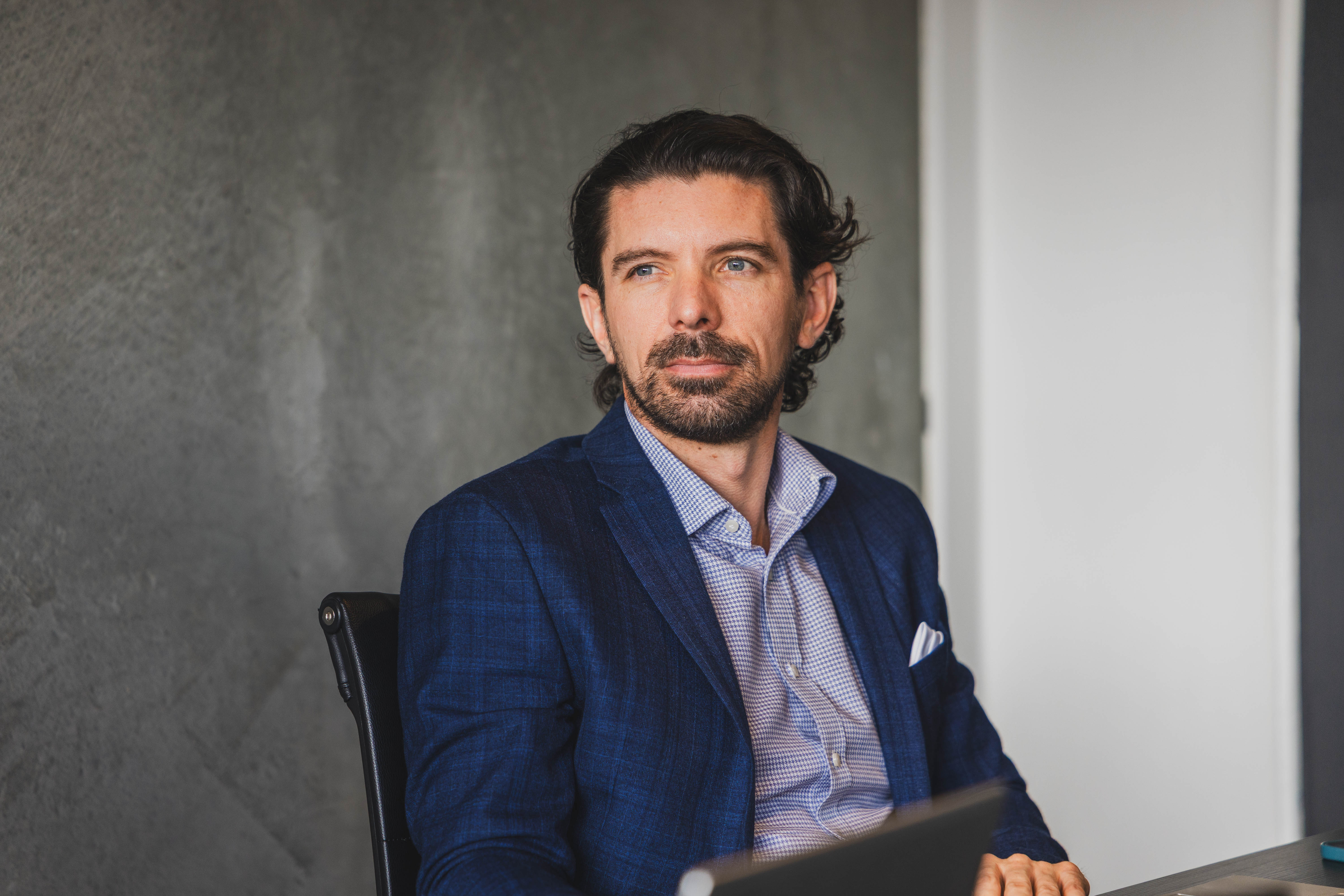 The Become Wealth CEO, Joseph, seated in a meeting. Joseph is in the office.