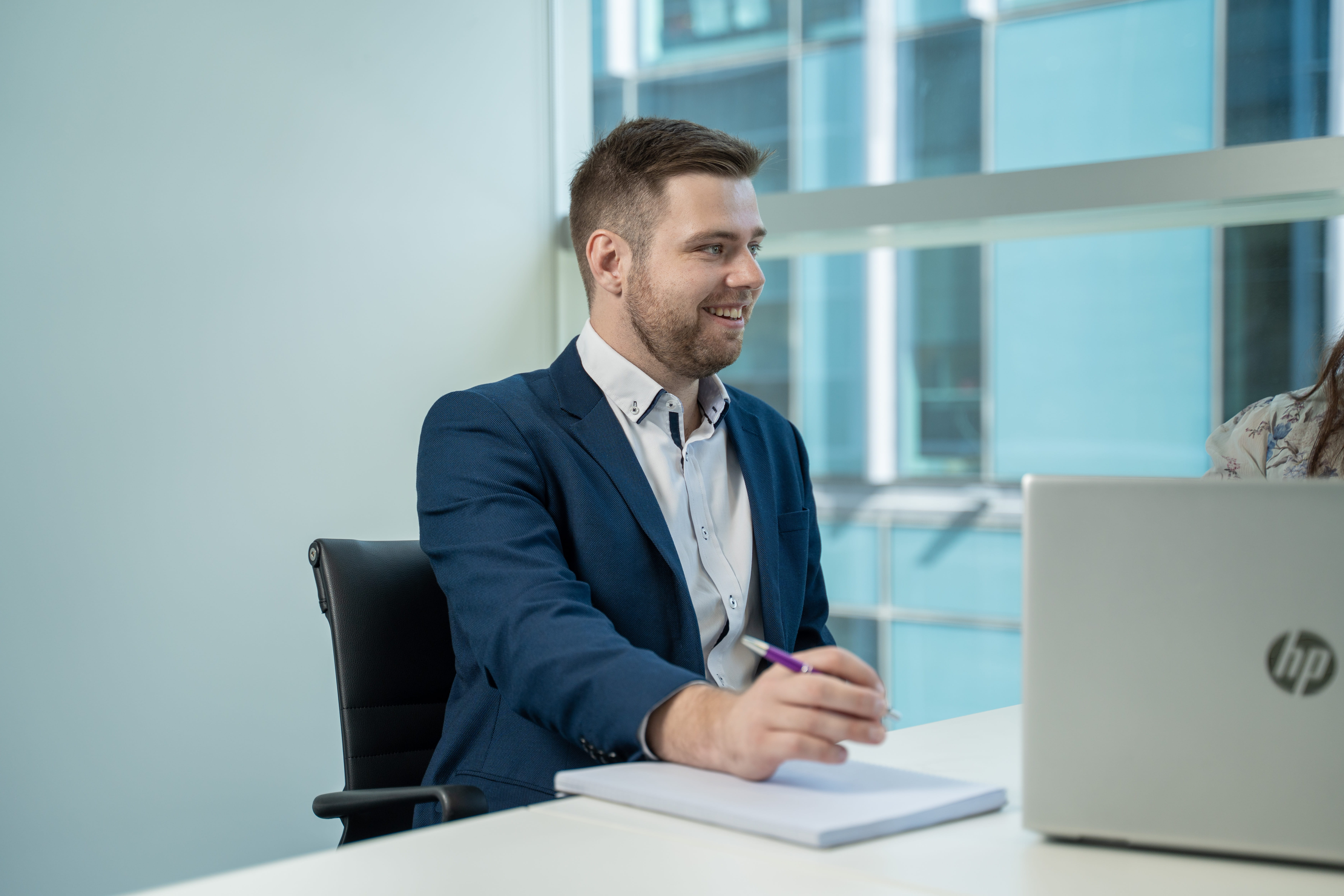 Josh Copeland, Financial Adviser at Become Wealth, laughing with a client (part visible, largely off-screen)