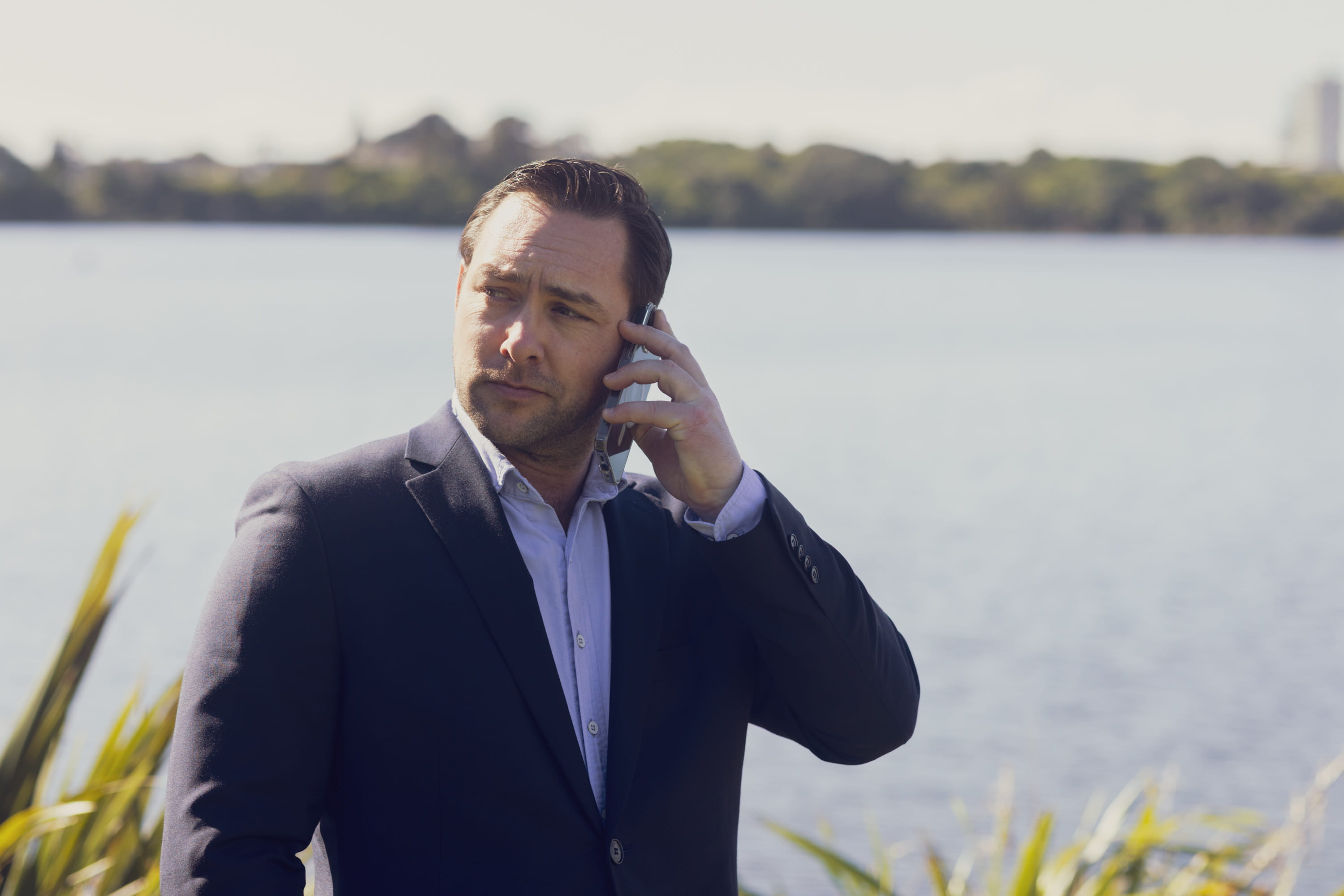 Marcus Mannering, a financial adviser at Become Wealth, on the phone, in front of Lake Pupuke (Auckland)