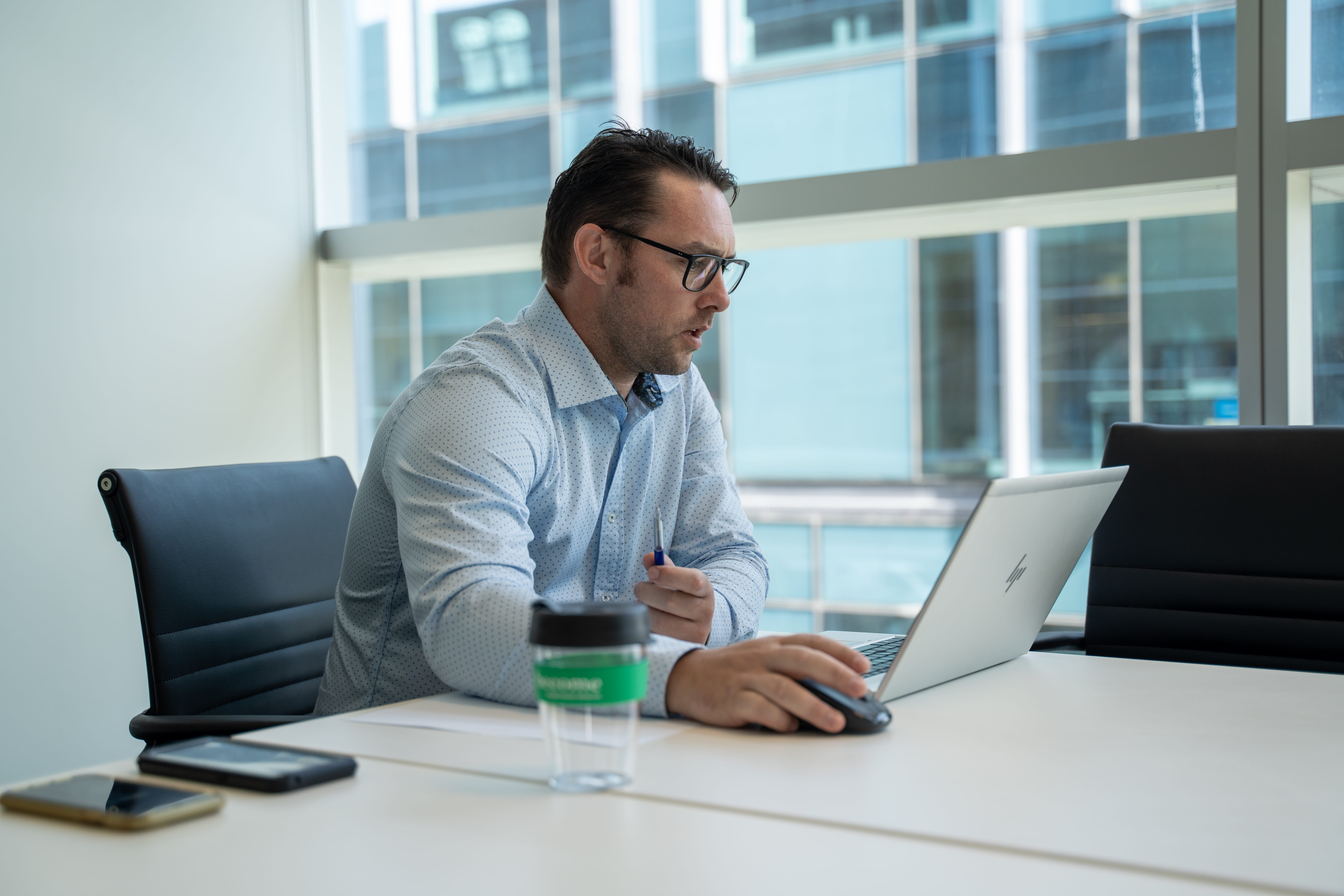 Marcus Mannering, financial adviser, in the firm's office, analysing something on his computer