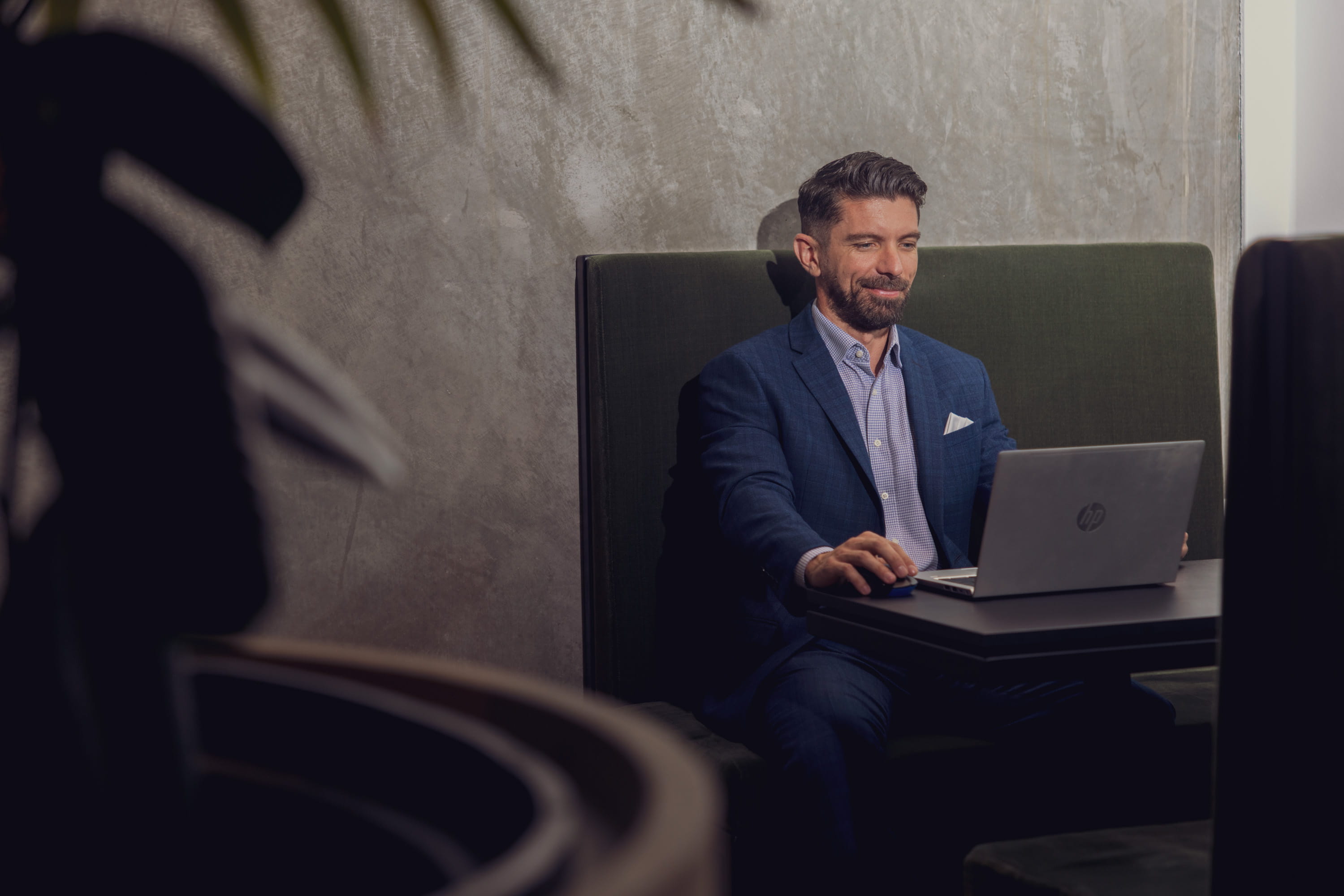 The Become Wealth CEO, Joseph Darby, sitting at his laptop in the office