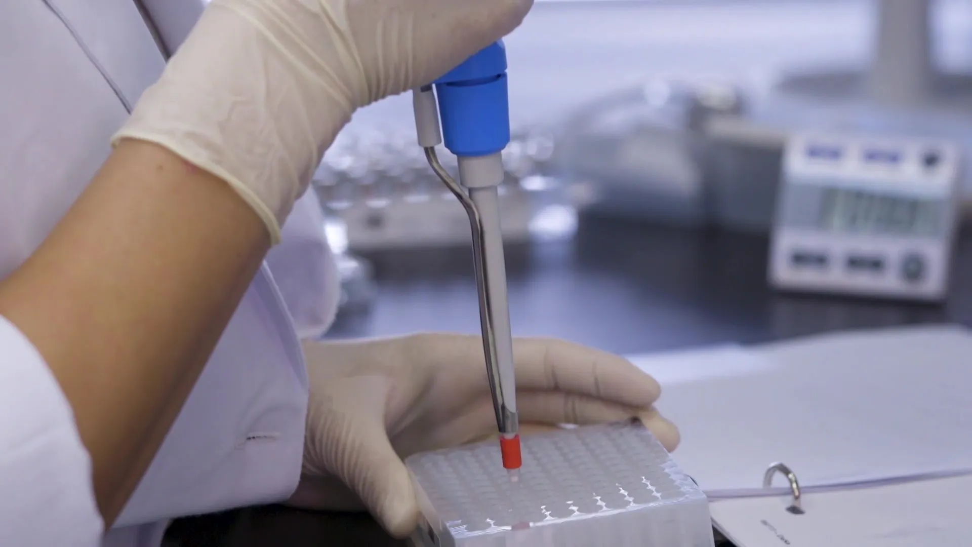 A scientist pipetting in a lab