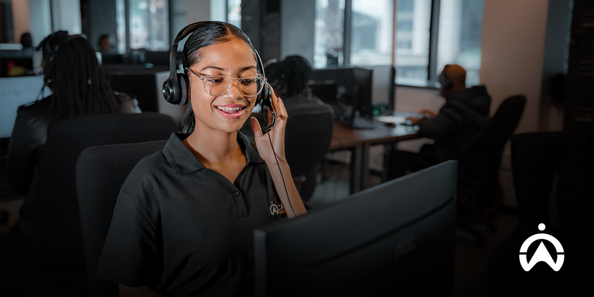 Cartrack Agent with headset in office environment working at a computer desk.