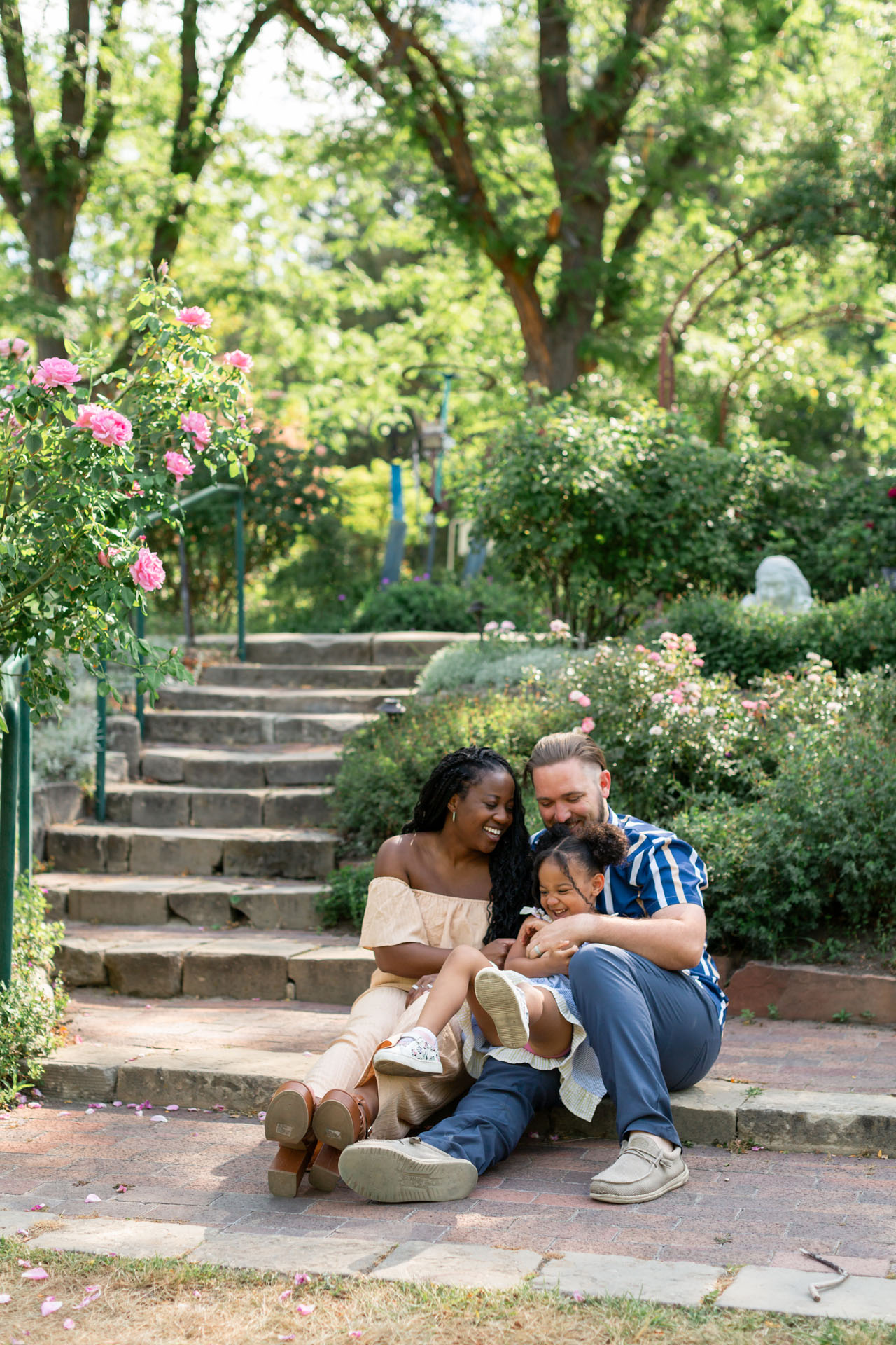 family sitting in rose garden together