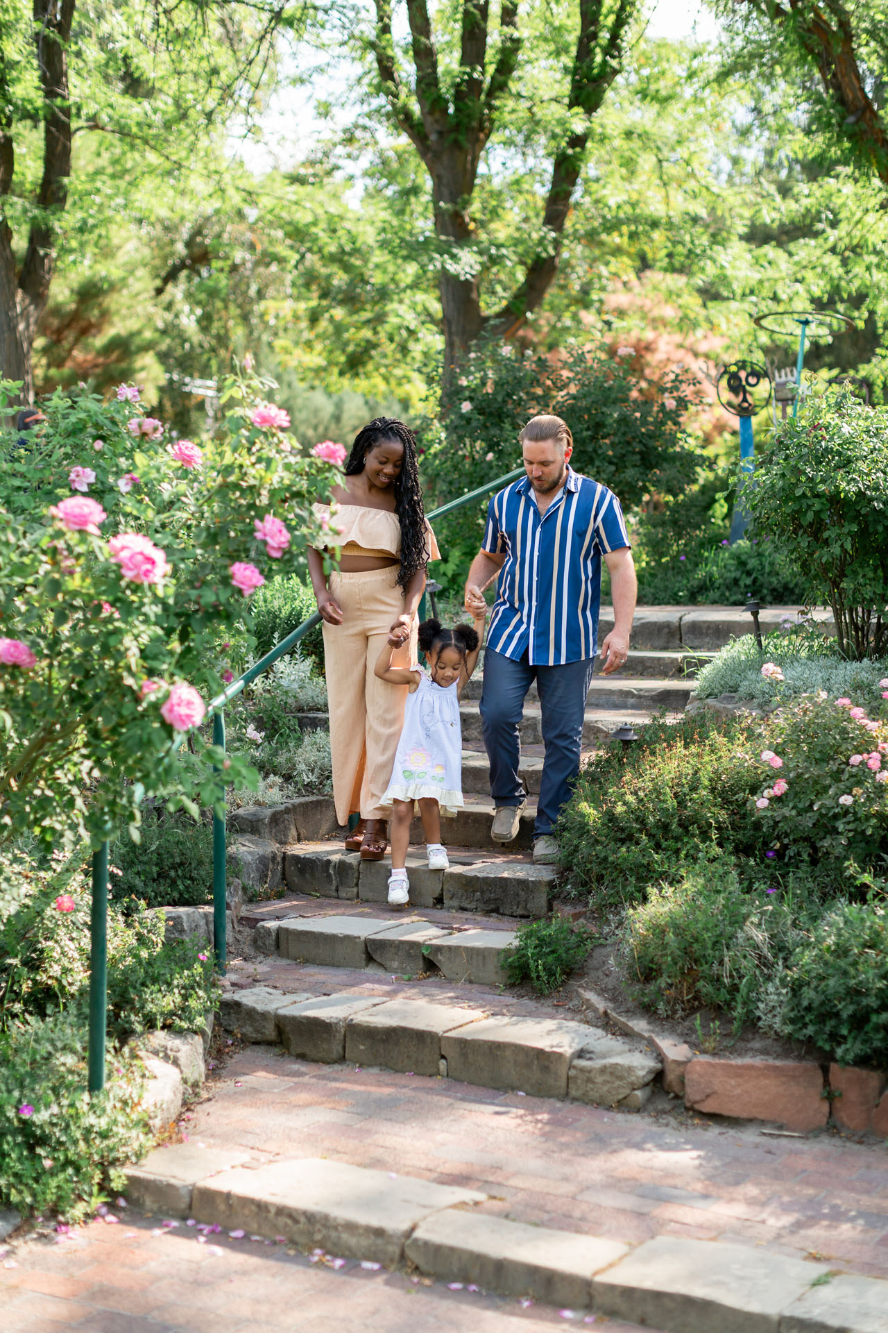 family holding hands and walking in a garden 