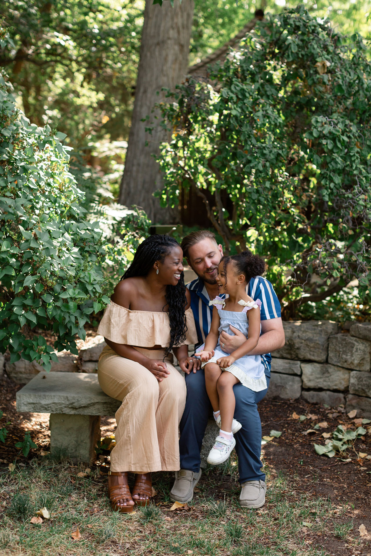 family laughing together during family photos in the garden