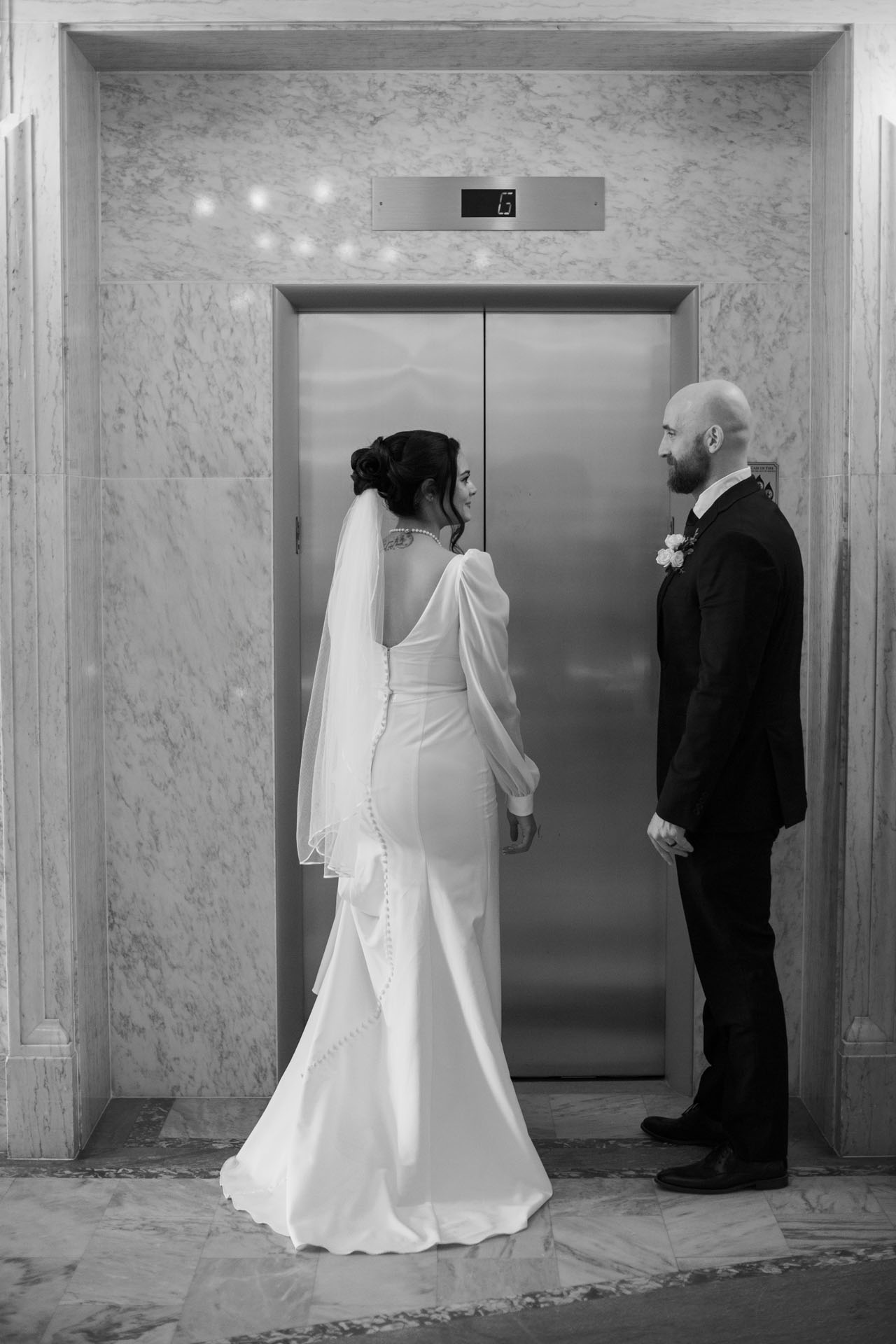 bride and groom getting in the elevator