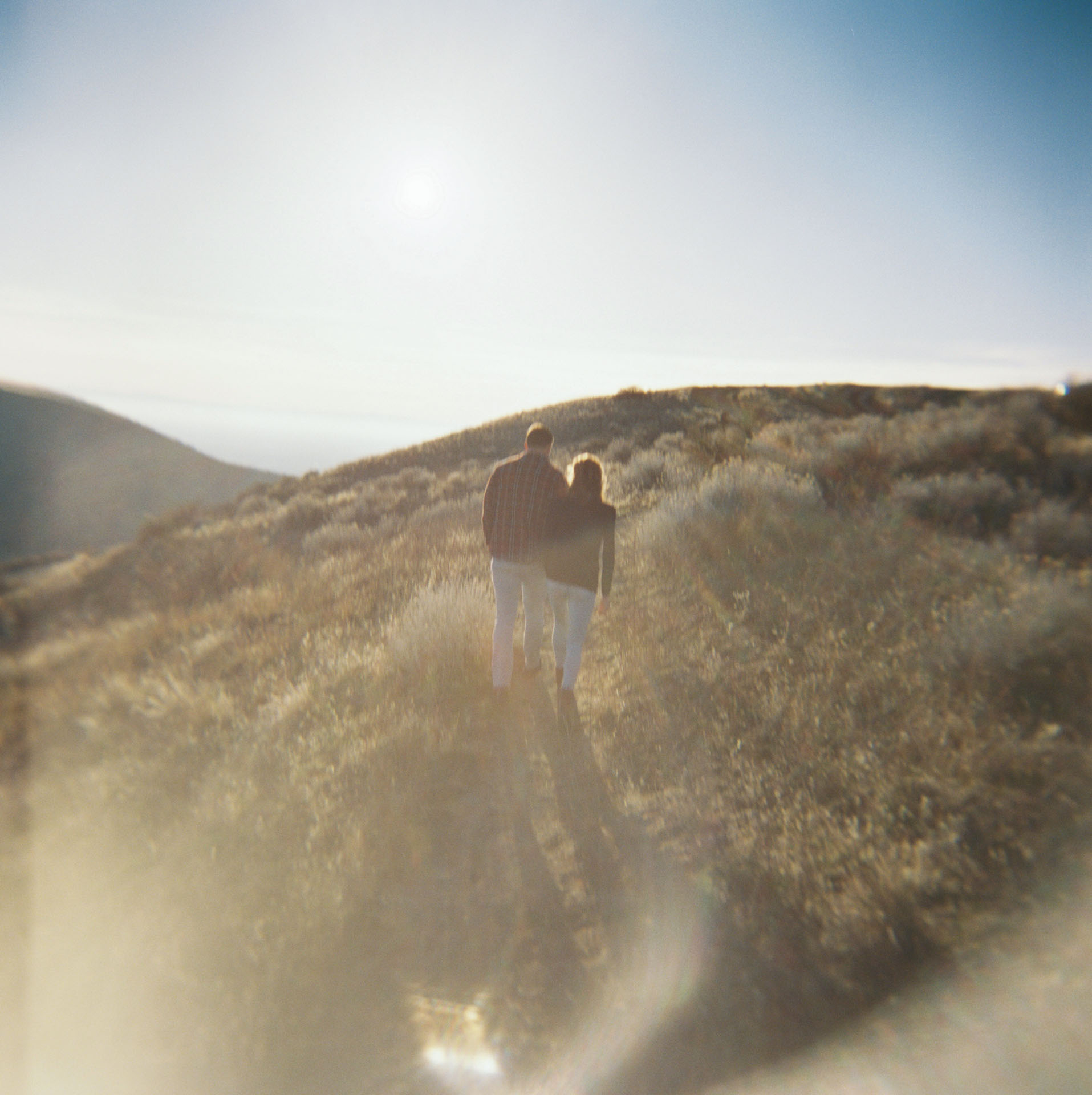 sun shining on a couple walking in the foothills