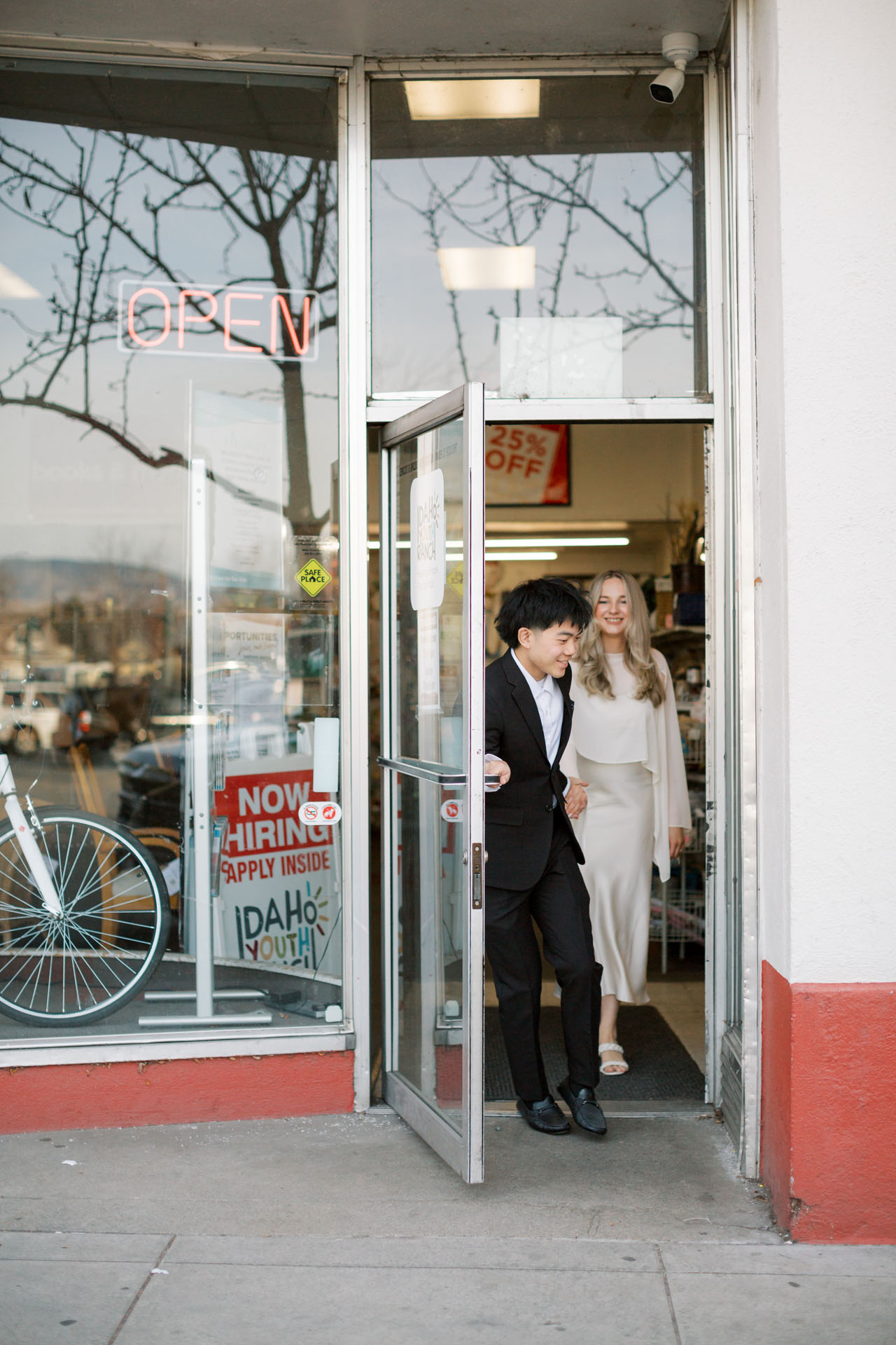 couple holding hands walking out of a thrift shop