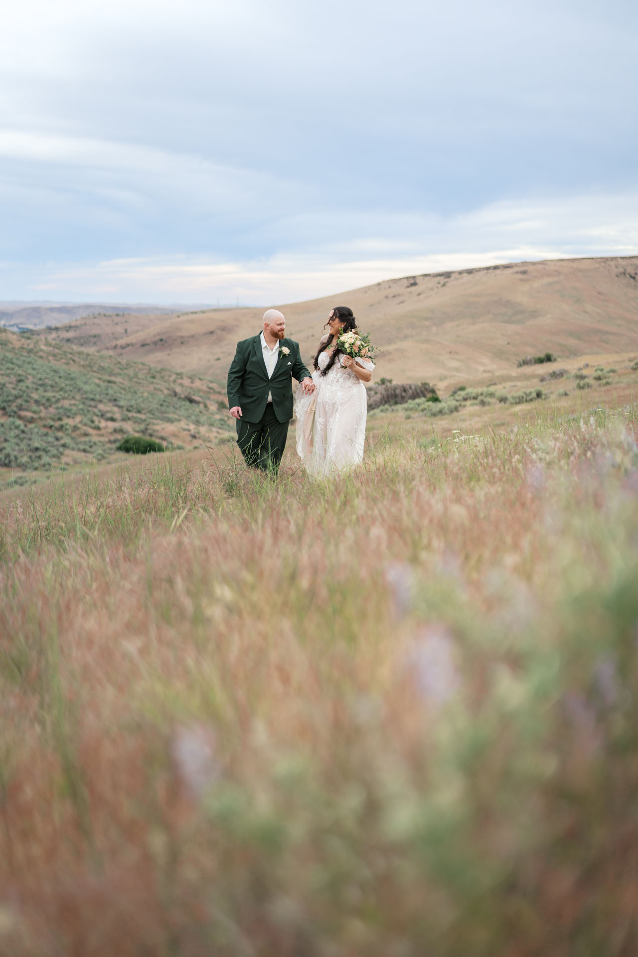 bride and groom walking in the foothills
