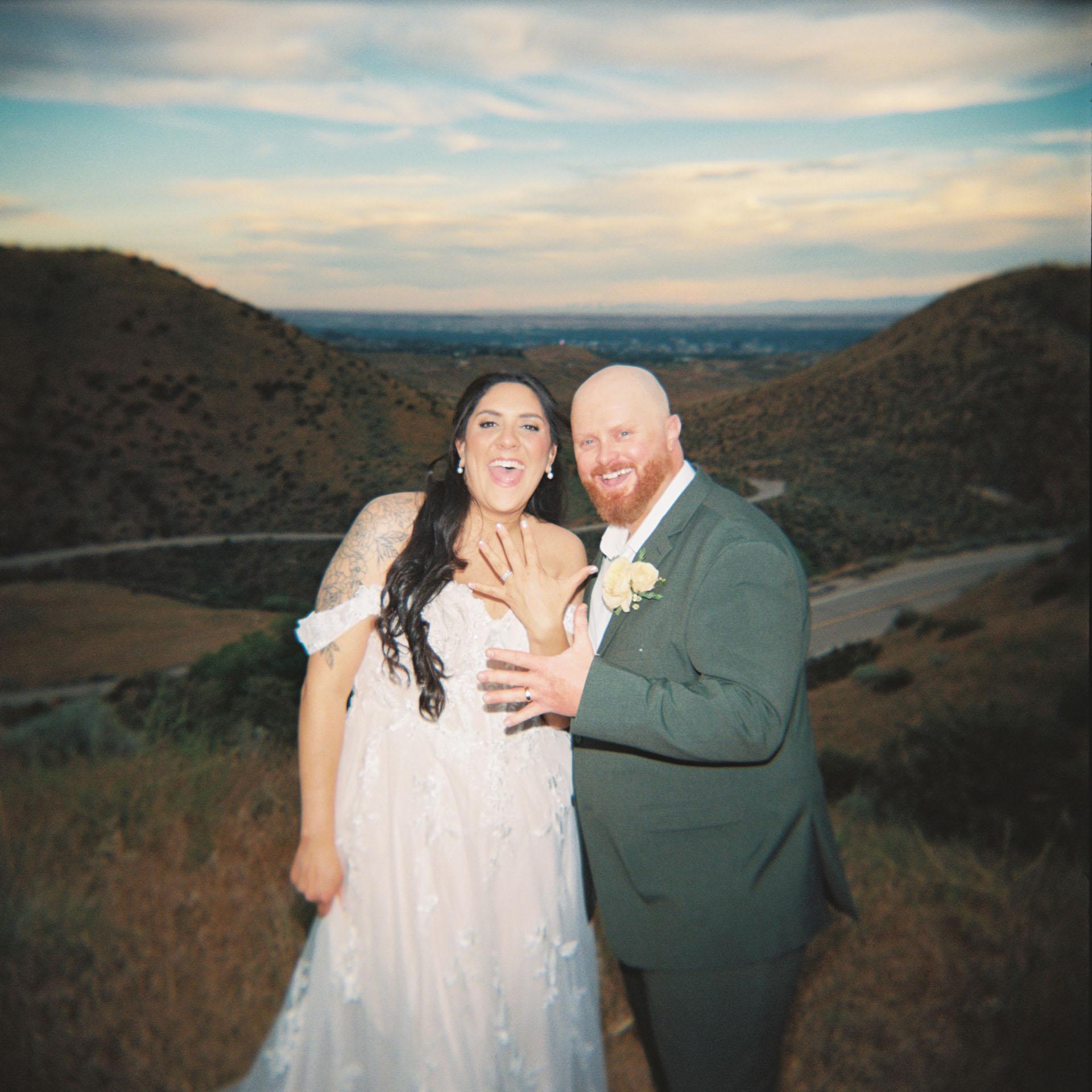 couple holding up their wedding rings on their hands after their elopement