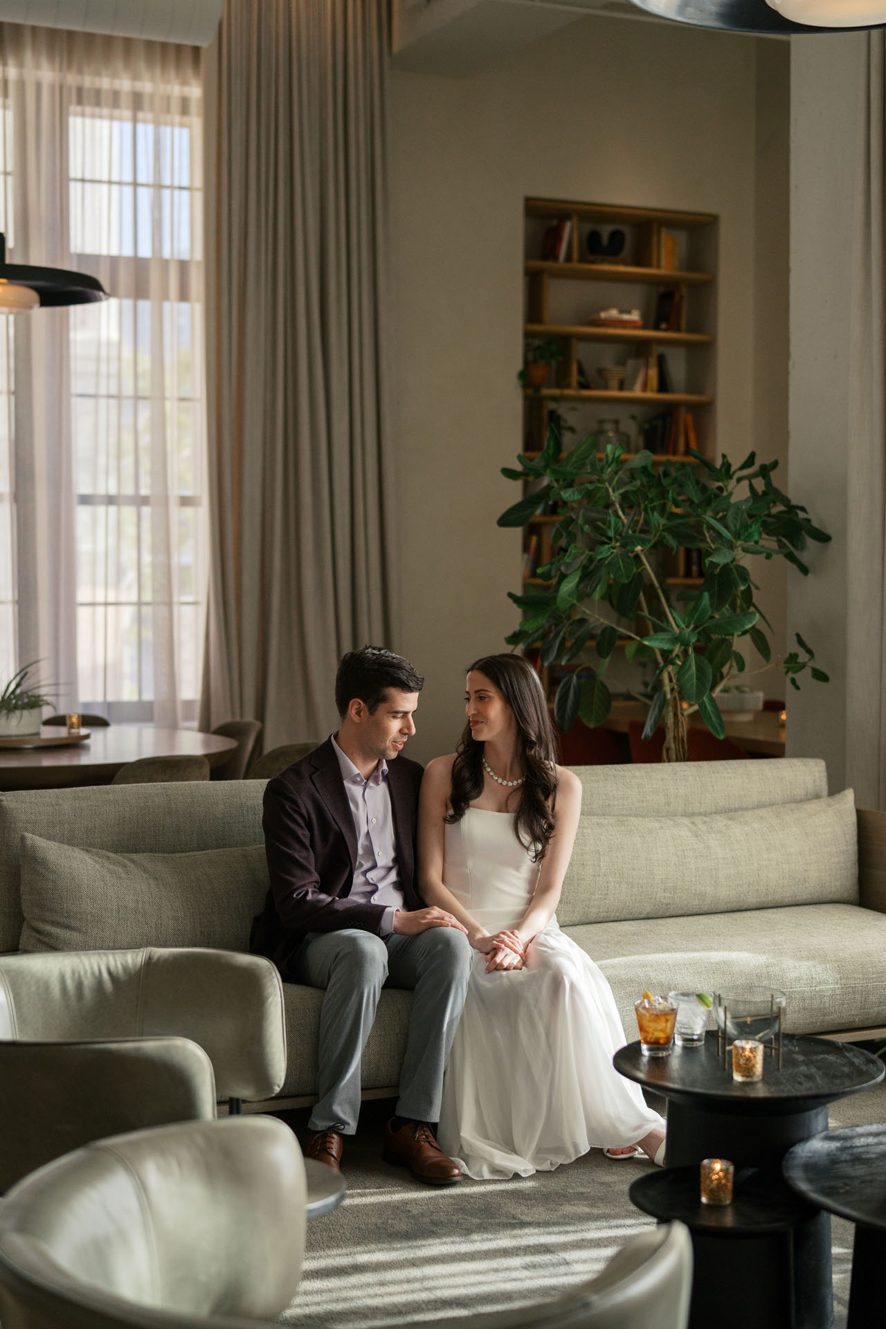 bride and groom sitting on the couch before their welcome party