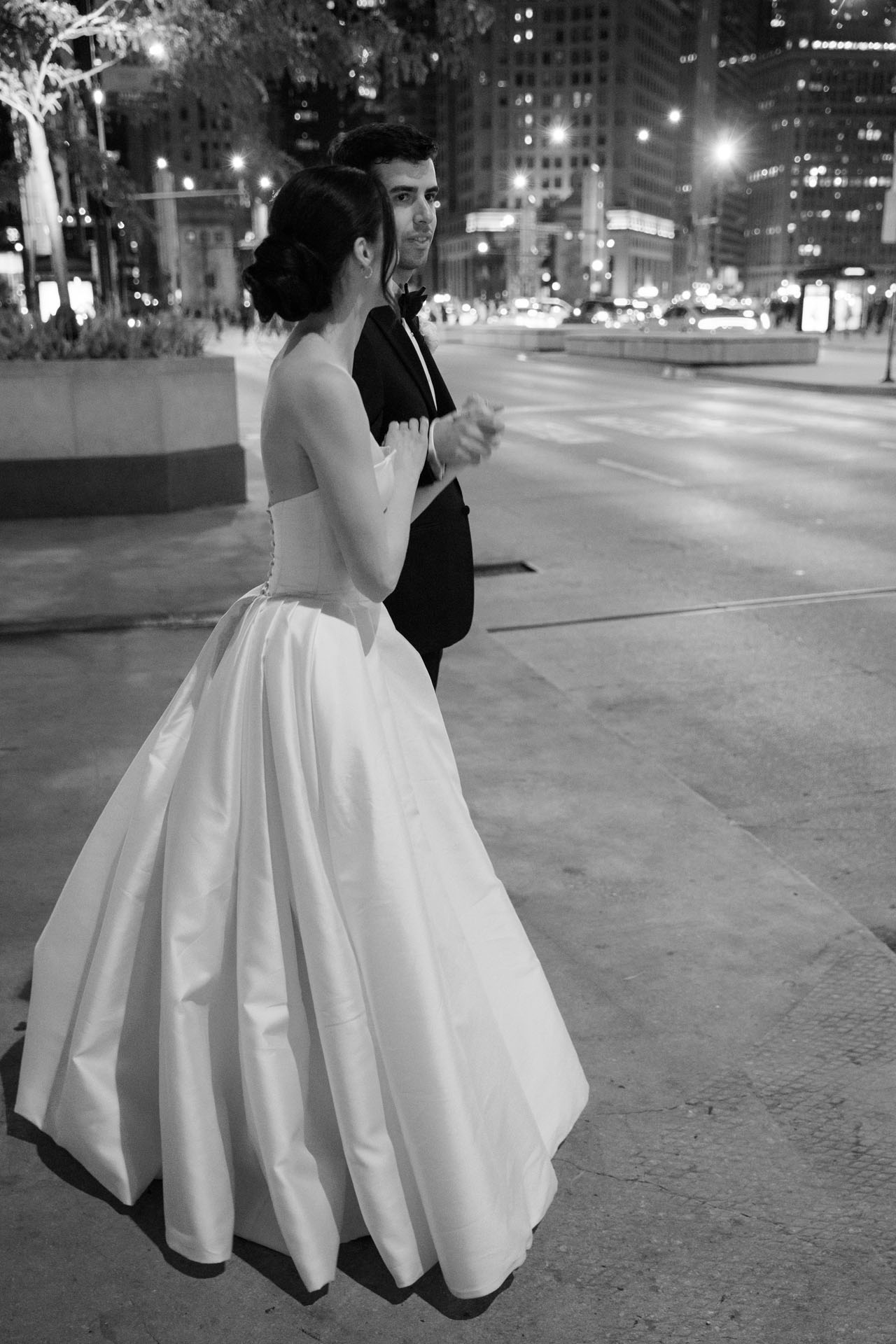 bride and groom holding hands getting ready to cross Michigan Avenue in Chicago