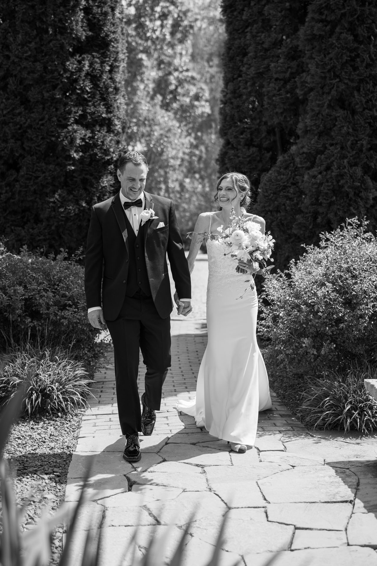 bride and groom walking through the garden