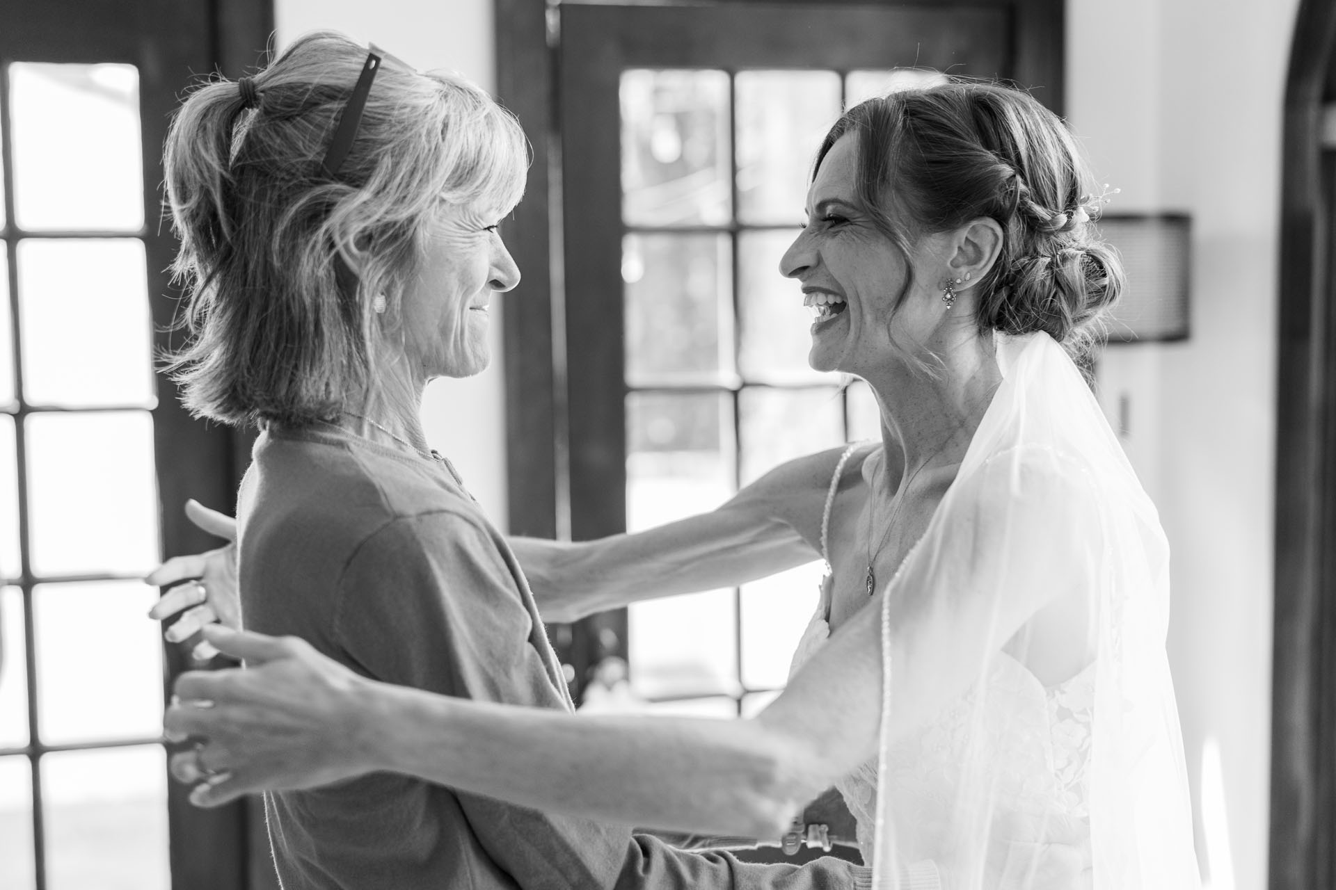 bride reaching in to hug her mom