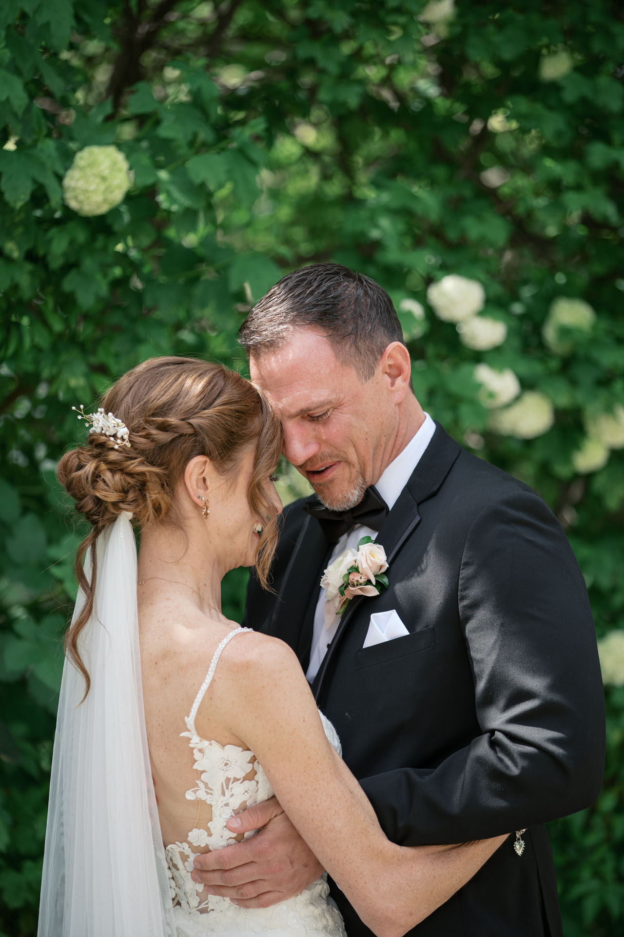 groom crying while hugging bride