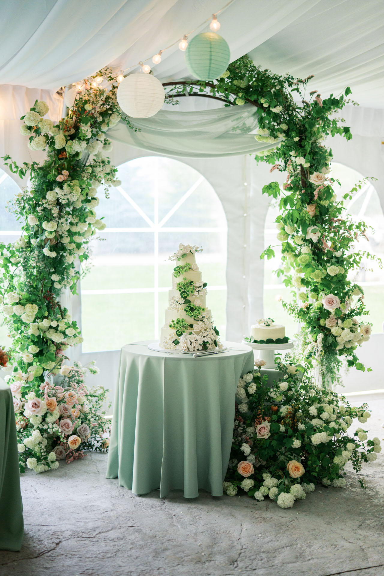 reception cake and floral arch