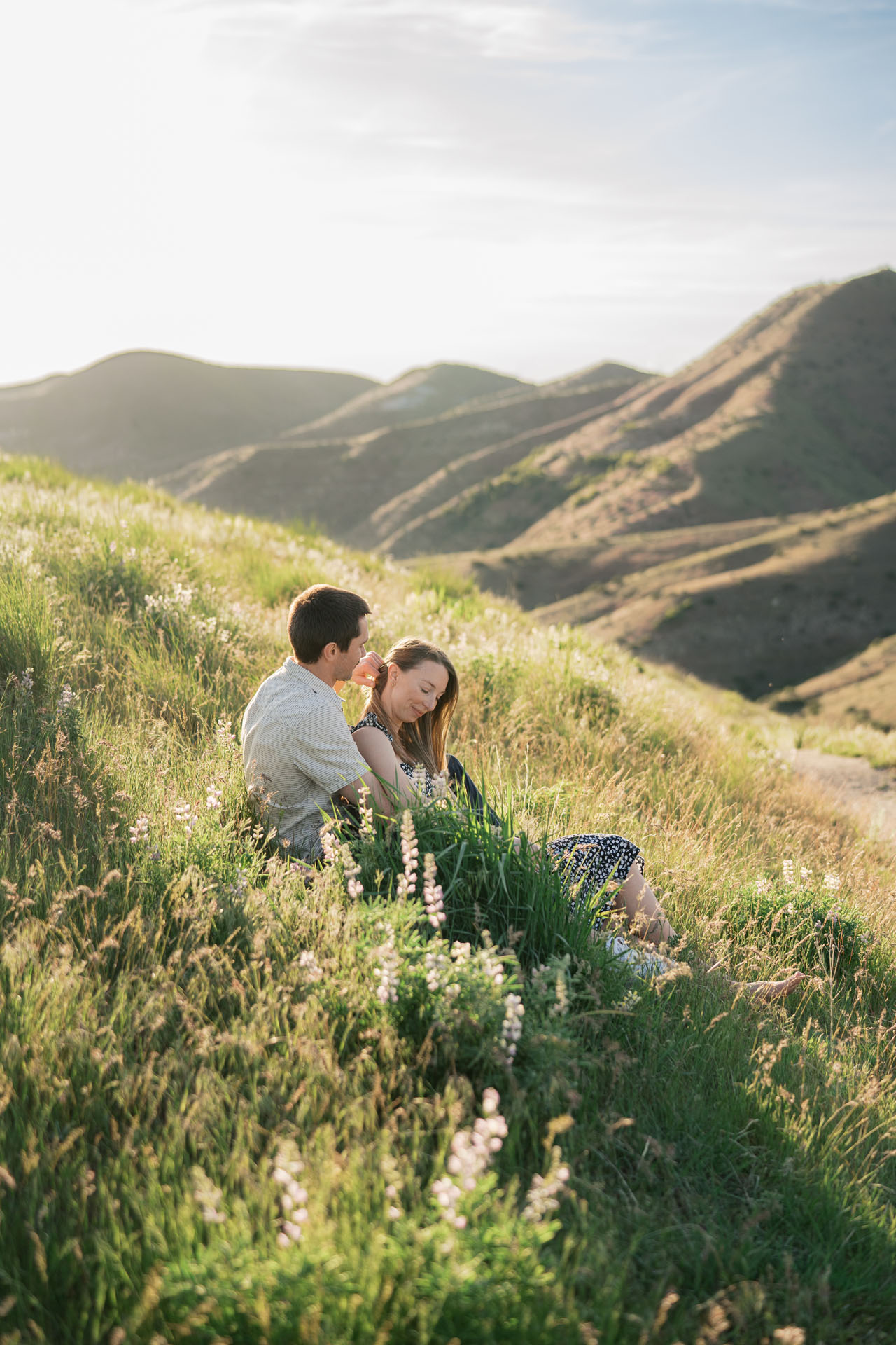 couple sitting next to the lupine wildflowers in the Boise foothills