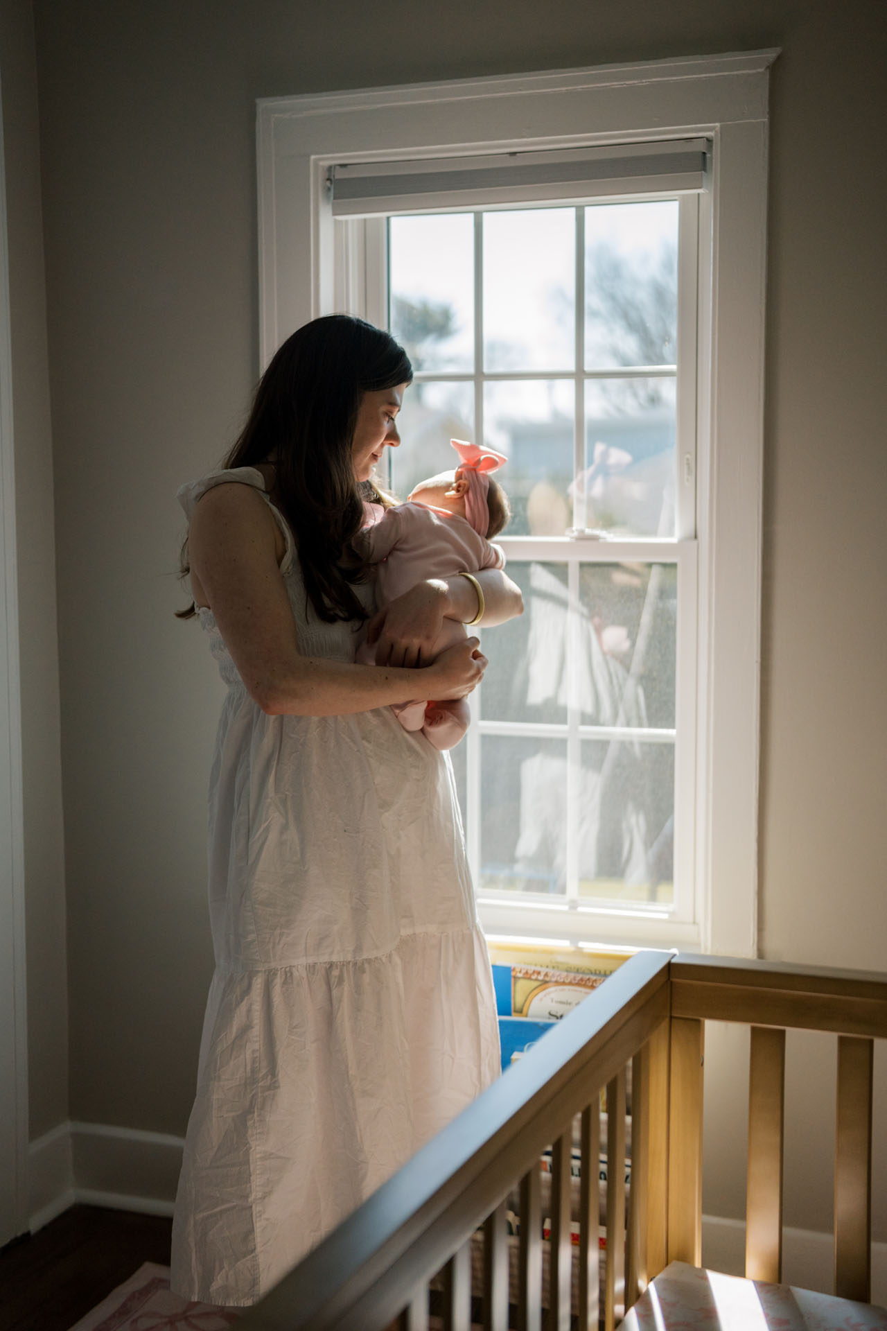 mom holding her new baby girl in the nursery