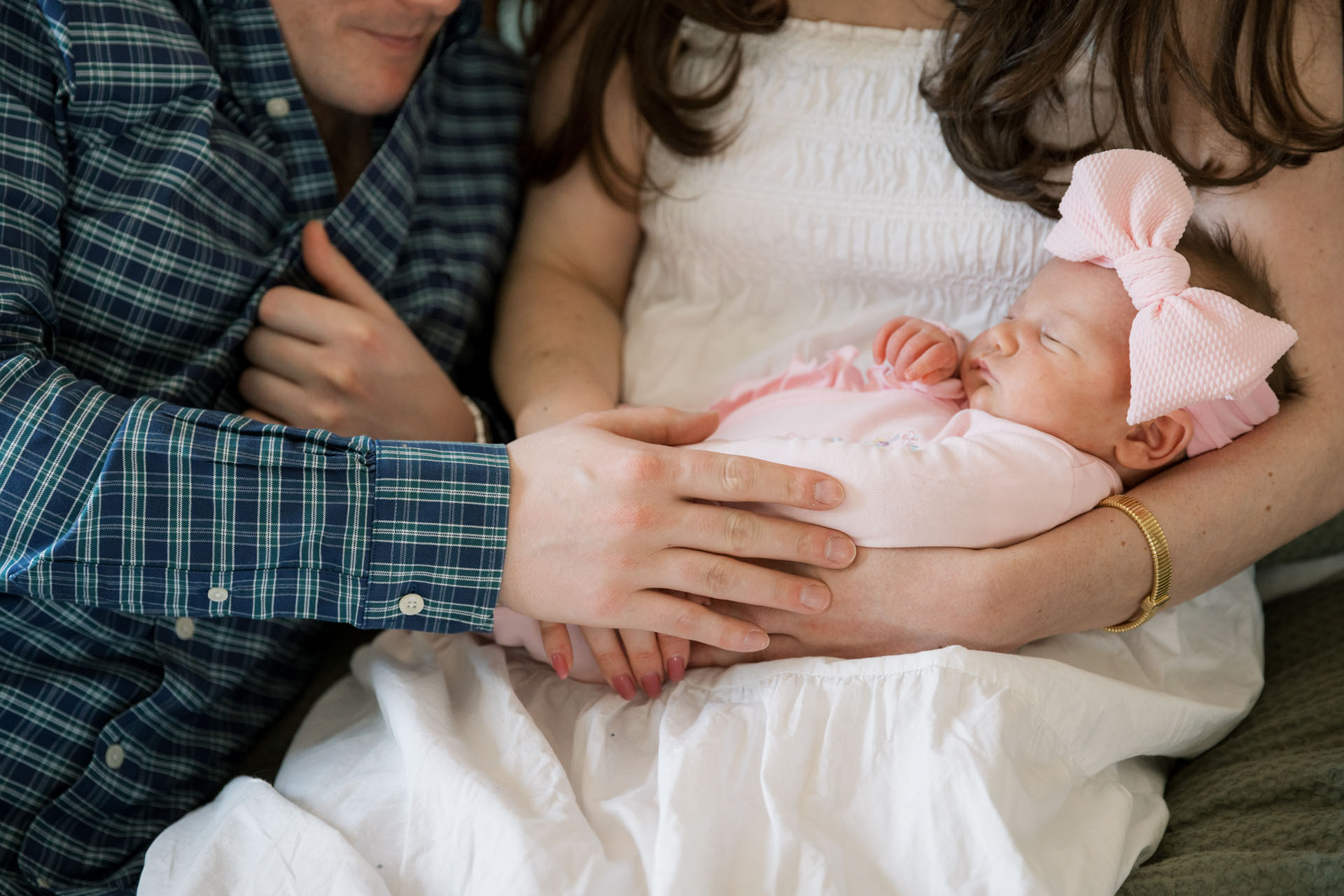 parents hands on their baby