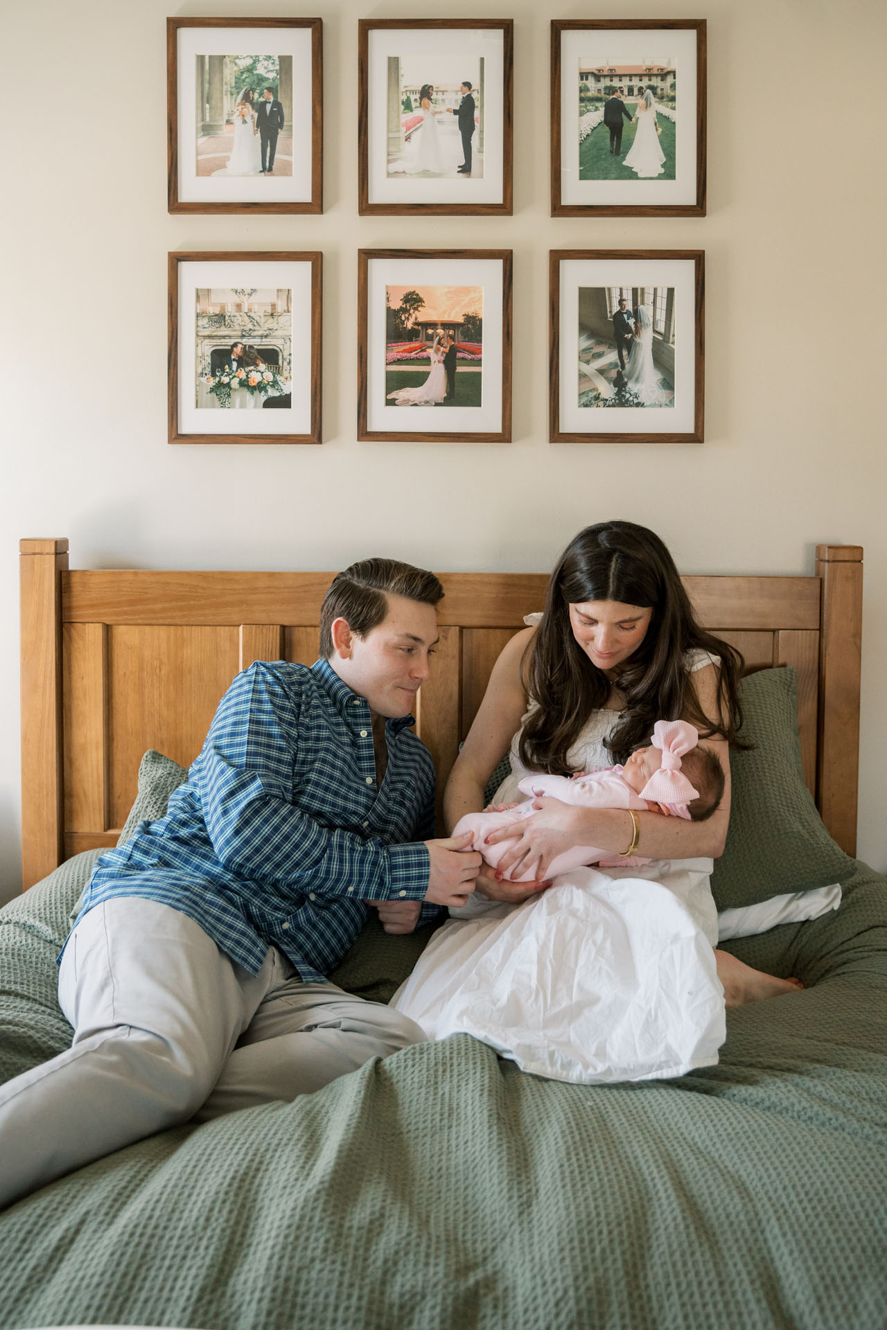 mom and dad sitting on their bed with their baby