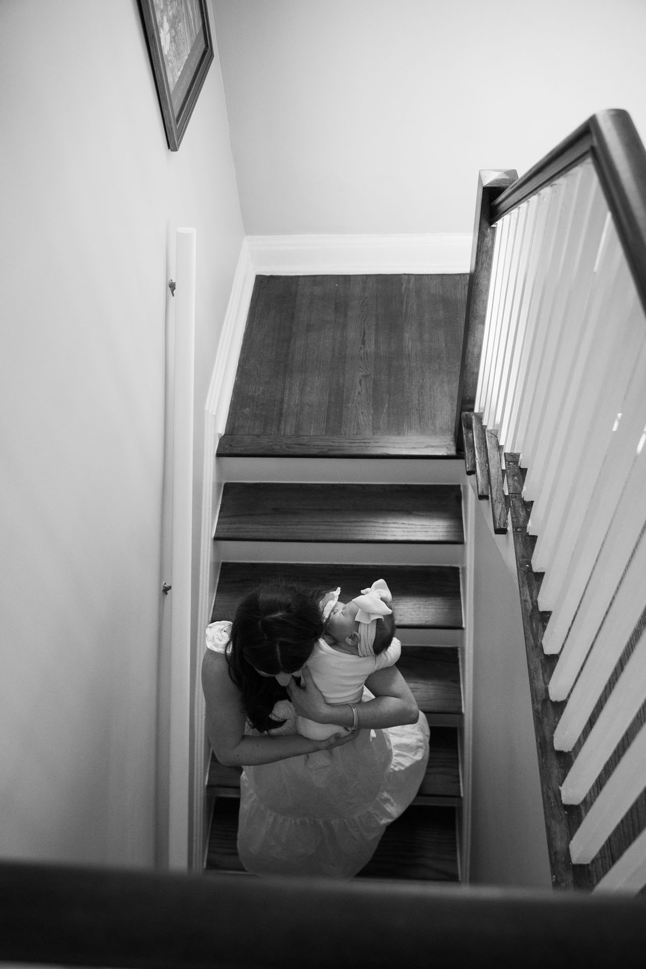 mom walking downstairs holding her baby