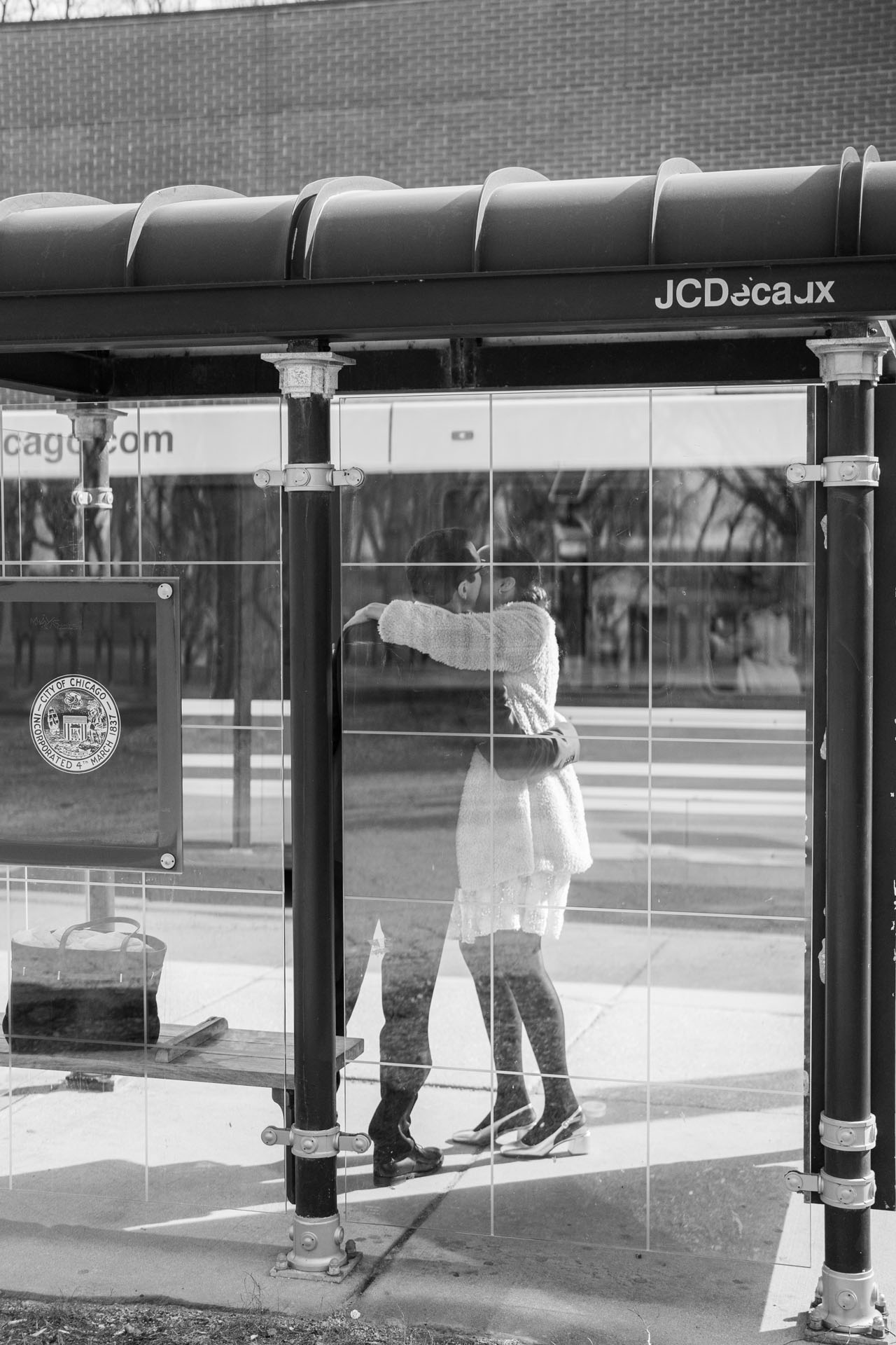 bride and groom kissing at a bus stop