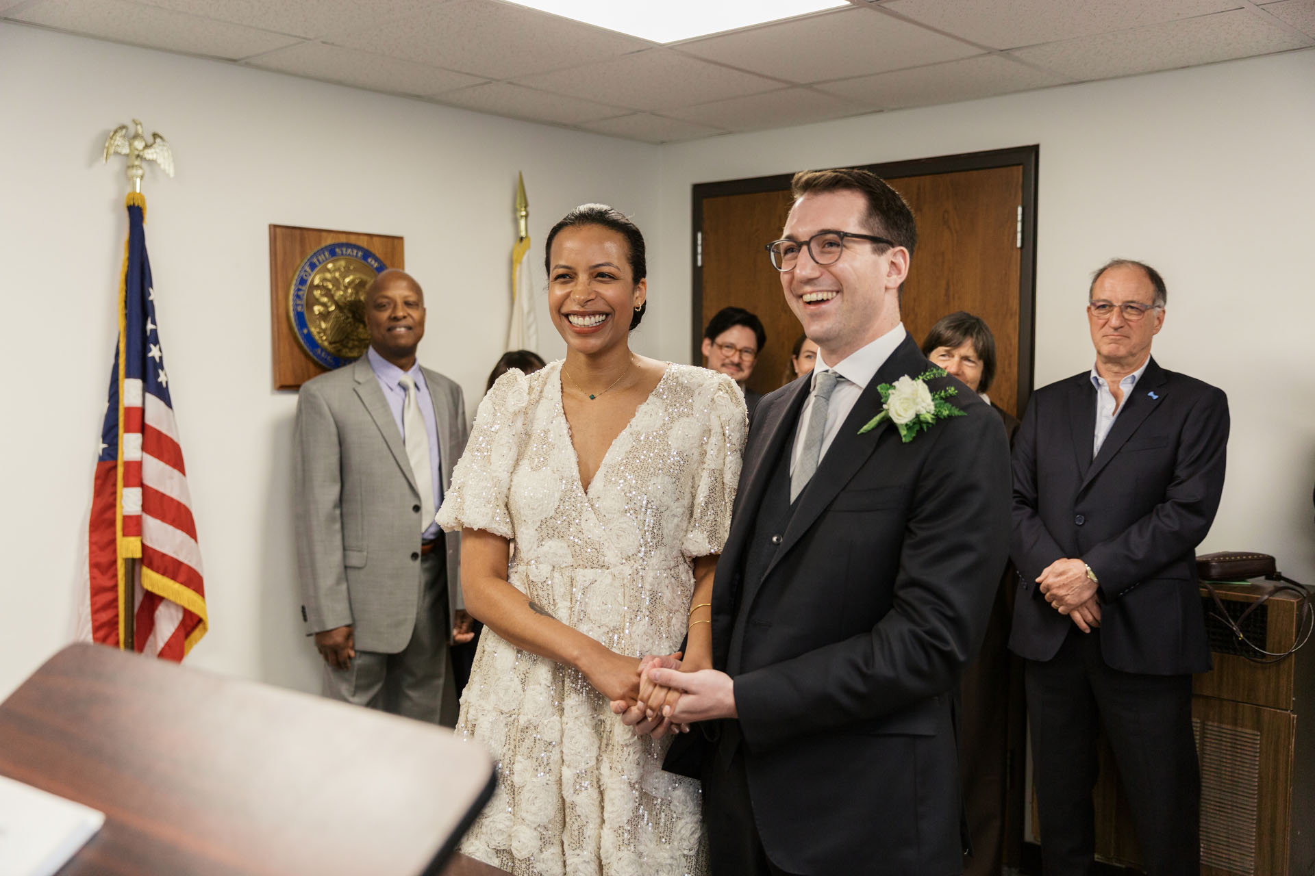 couple holding hands in the judge's chambers at City Hall