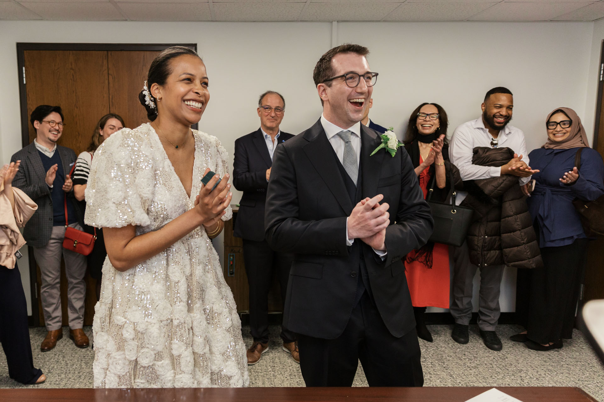 couple smiling and clapping after being pronounced husband and wife