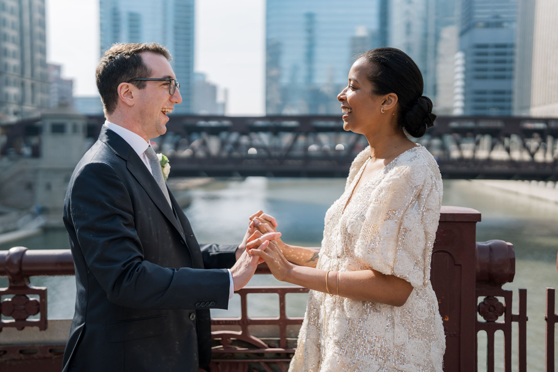bride and groom holding hands on a bridge in Chicago