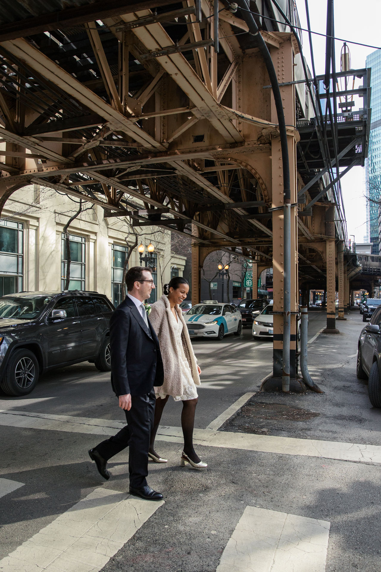 bride and groom walking under the L tracks in Chicago