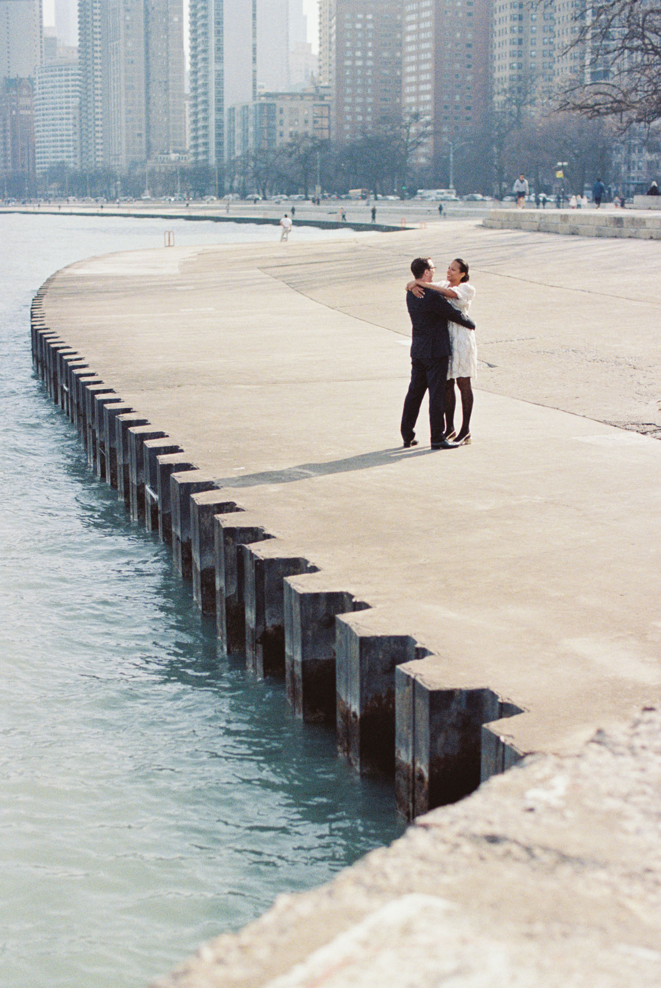 bride and groom with their arms around each other on the Chicago lakefront path