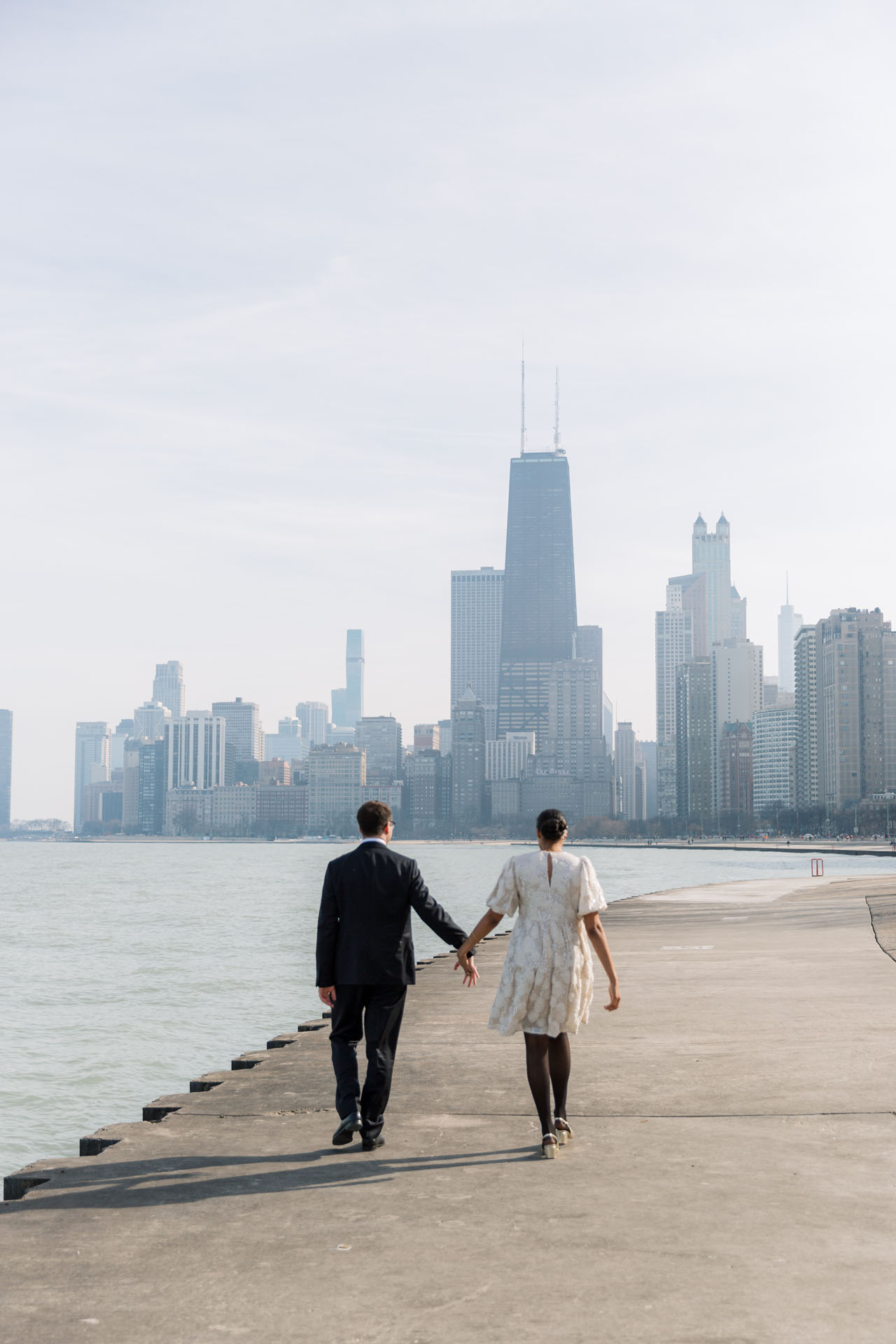 bride and groom walking along the lakefront in Chicago