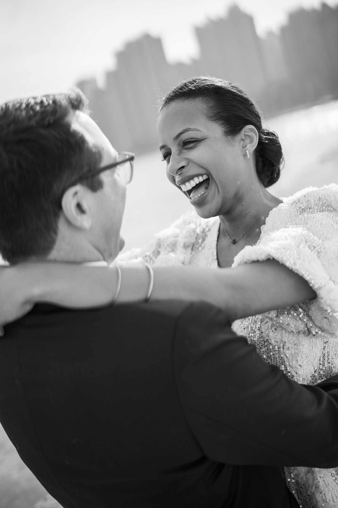 bride's face as she laughs with her groom