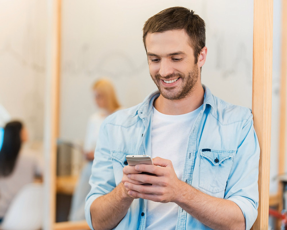 Man completing an online skincare assessment on his phone through Phoenix.