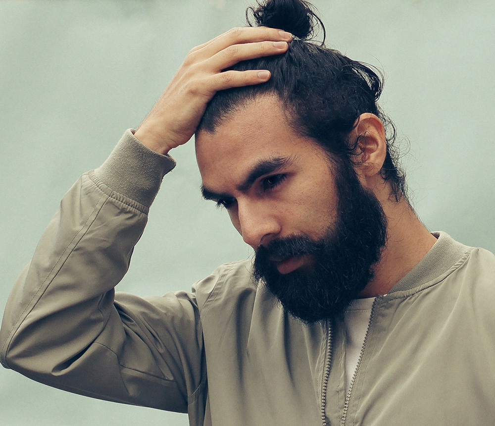 Man touching his hair for an article about whether minoxidil causes weight gain in men