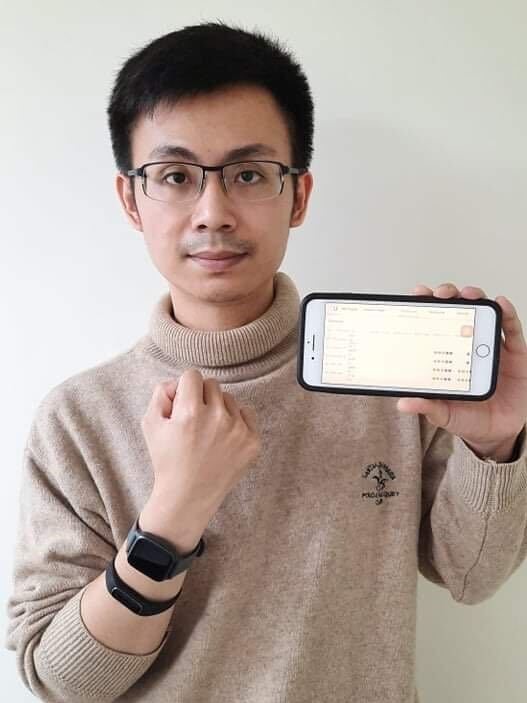 Han-Ping with his smartphone in one hand and two smartwatches on his wrist