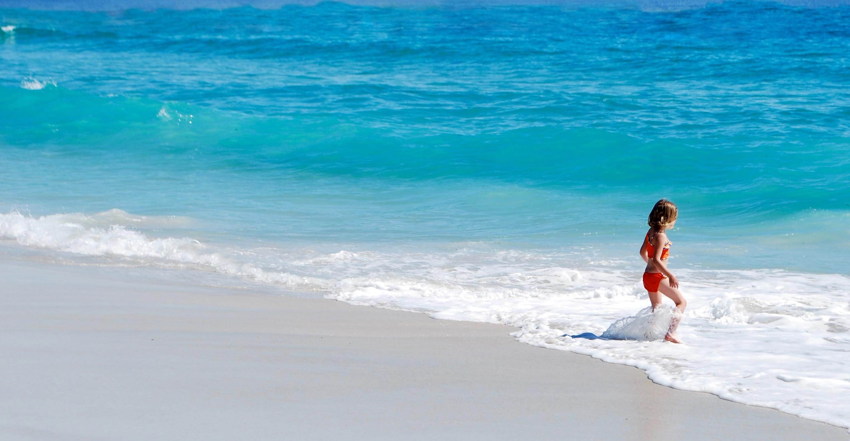 Girl playing on litter free white sand beach