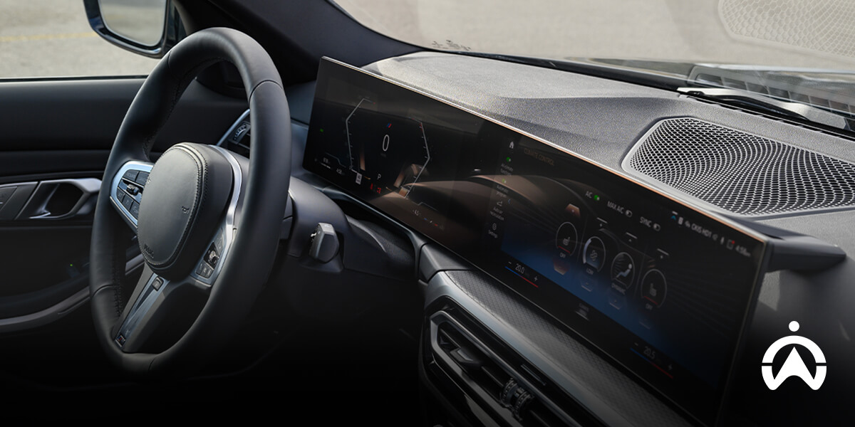 A sleek car interior showcasing a modern dashboard with a large display and steering wheel, featuring digital controls and gauges.