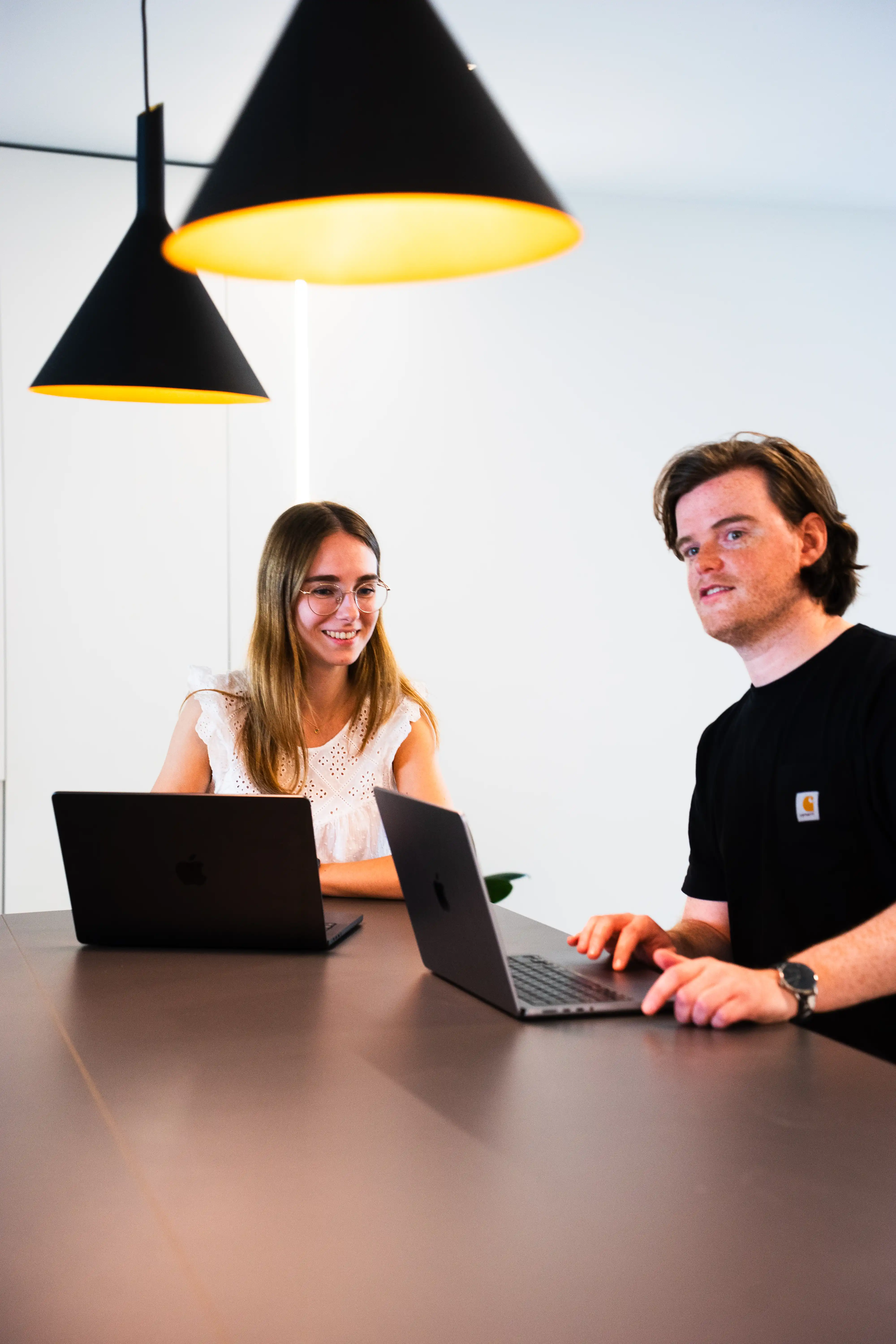 A man and woman working together on their laptop.