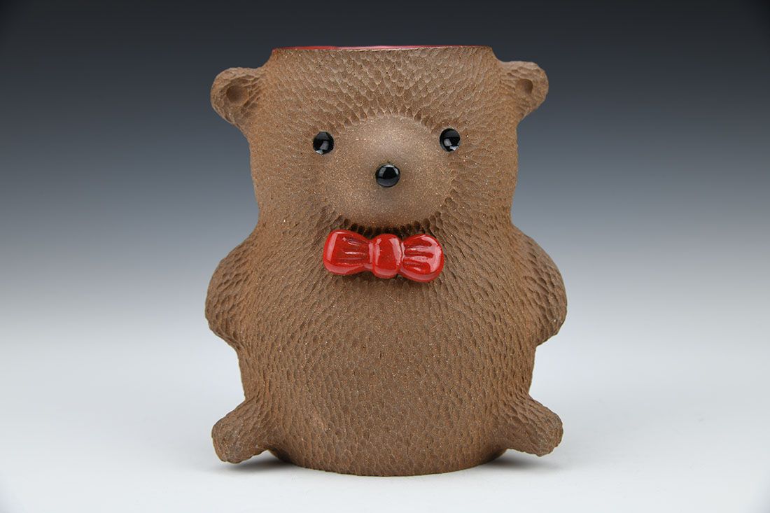 A panda, brown, and white bear drinking vessels.