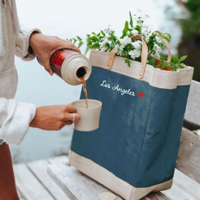 A woman handing a gift bag to an attendee at an event