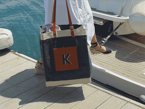 People sitting on a table enjoying friends with a market bag in front of them