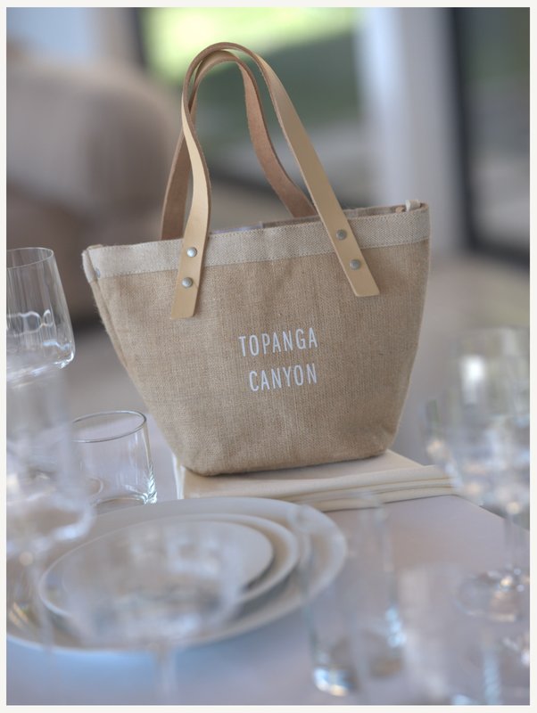 A woman handing a gift bag to an attendee at an event