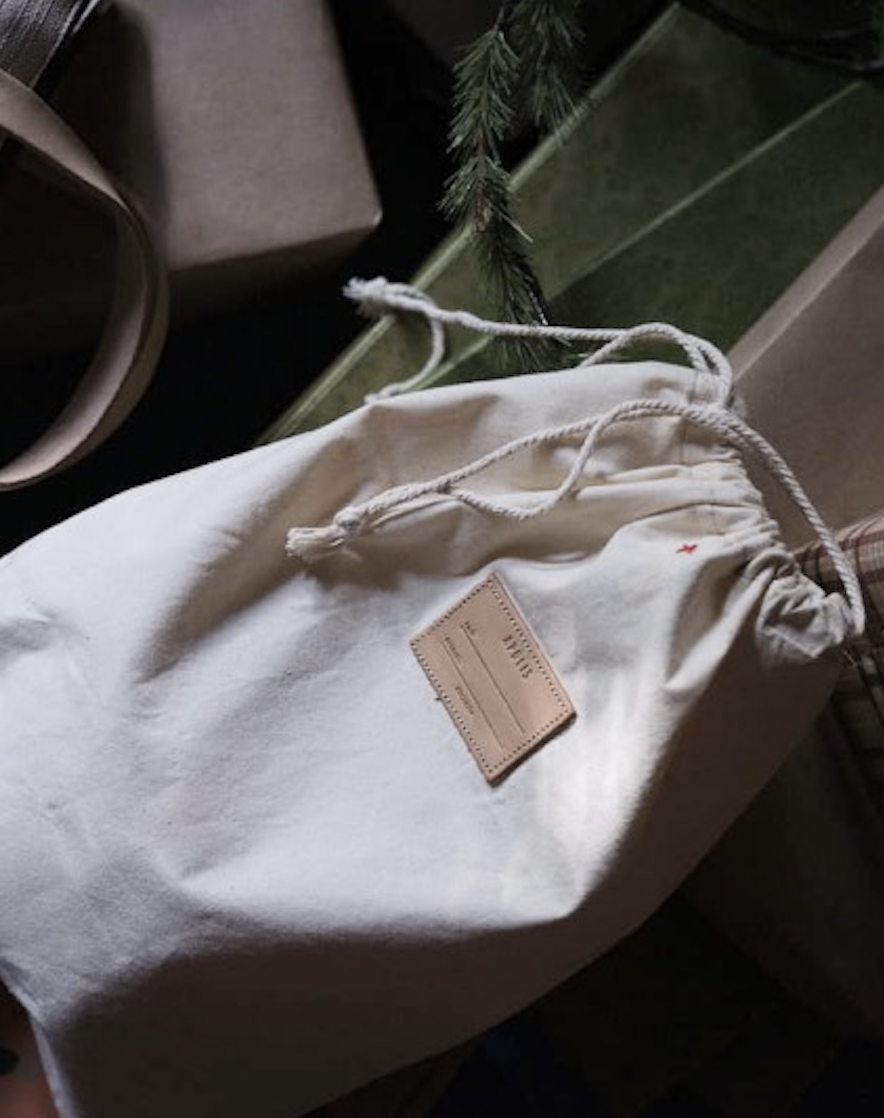 People sitting on a table enjoying friends with a market bag in front of them